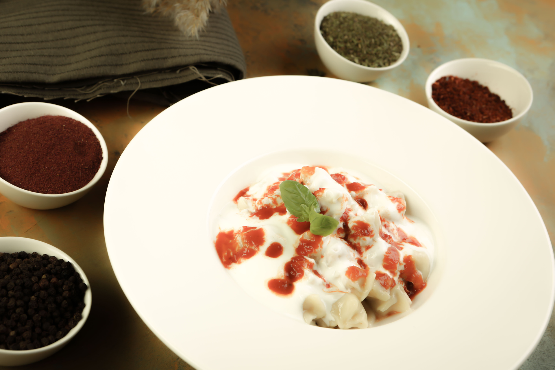 Overhead flat-lay of all ingredients for Savory Armenian Manti with Garlic Yogurt and Sumac Butter laid out on a kitchen surface.