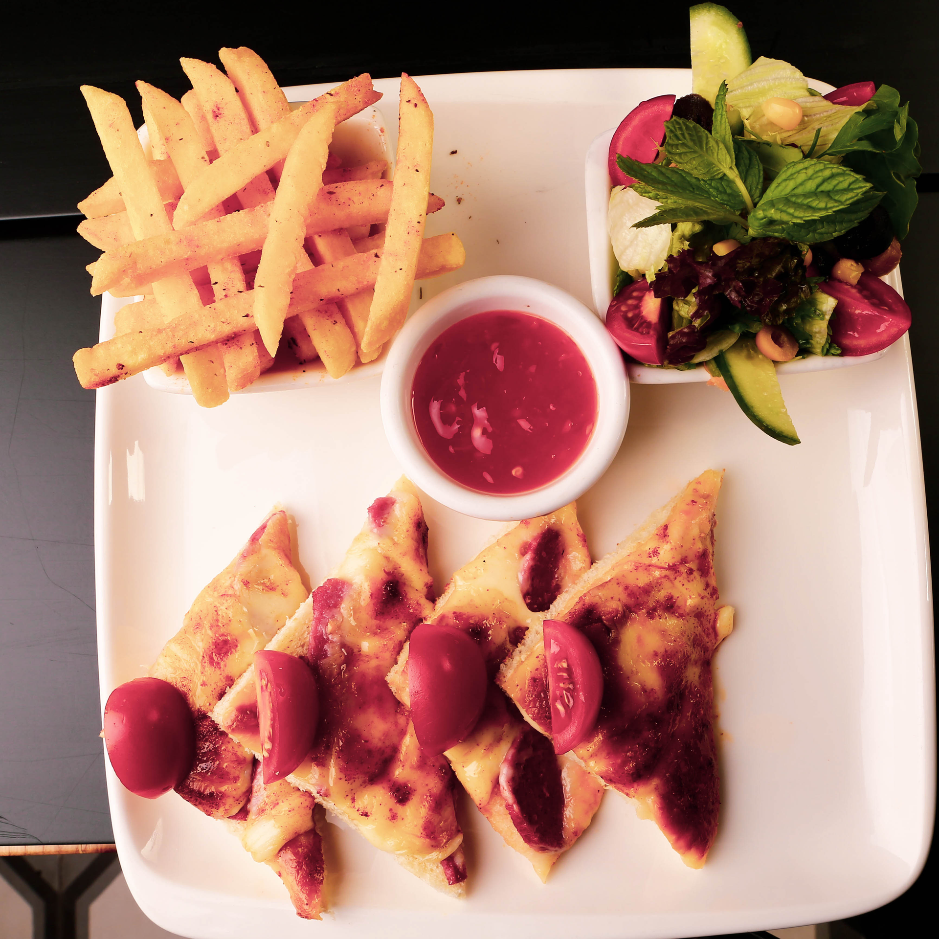 Overhead flat-lay of all ingredients for Savory Cypriot Halloumi Fries with Pomegranate Molasses laid out on a kitchen surface.