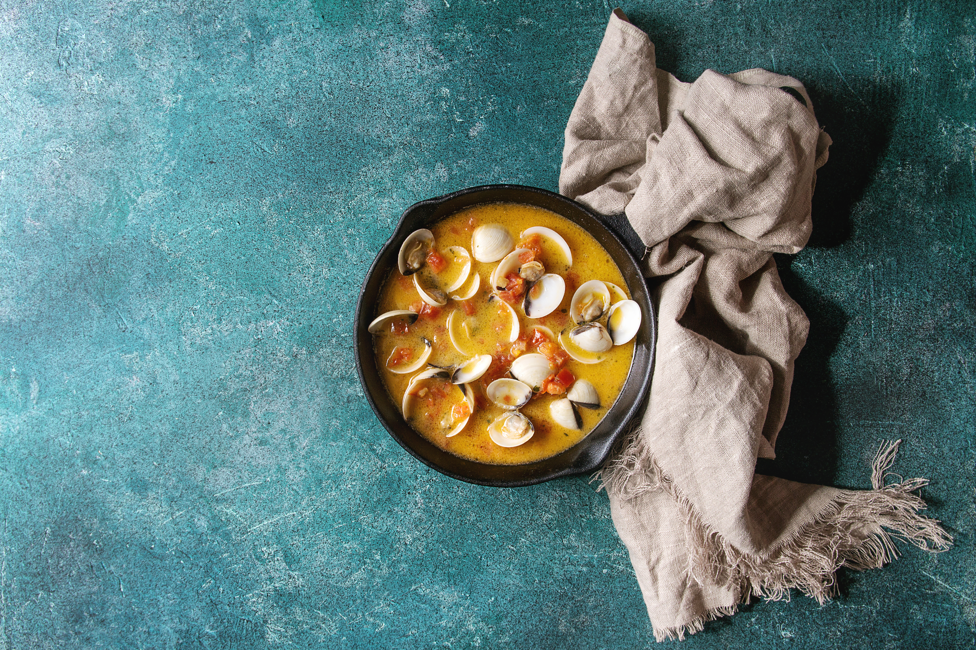 Overhead flat-lay of all ingredients for Savory French Bouillabaisse with Rouille laid out on a kitchen surface.