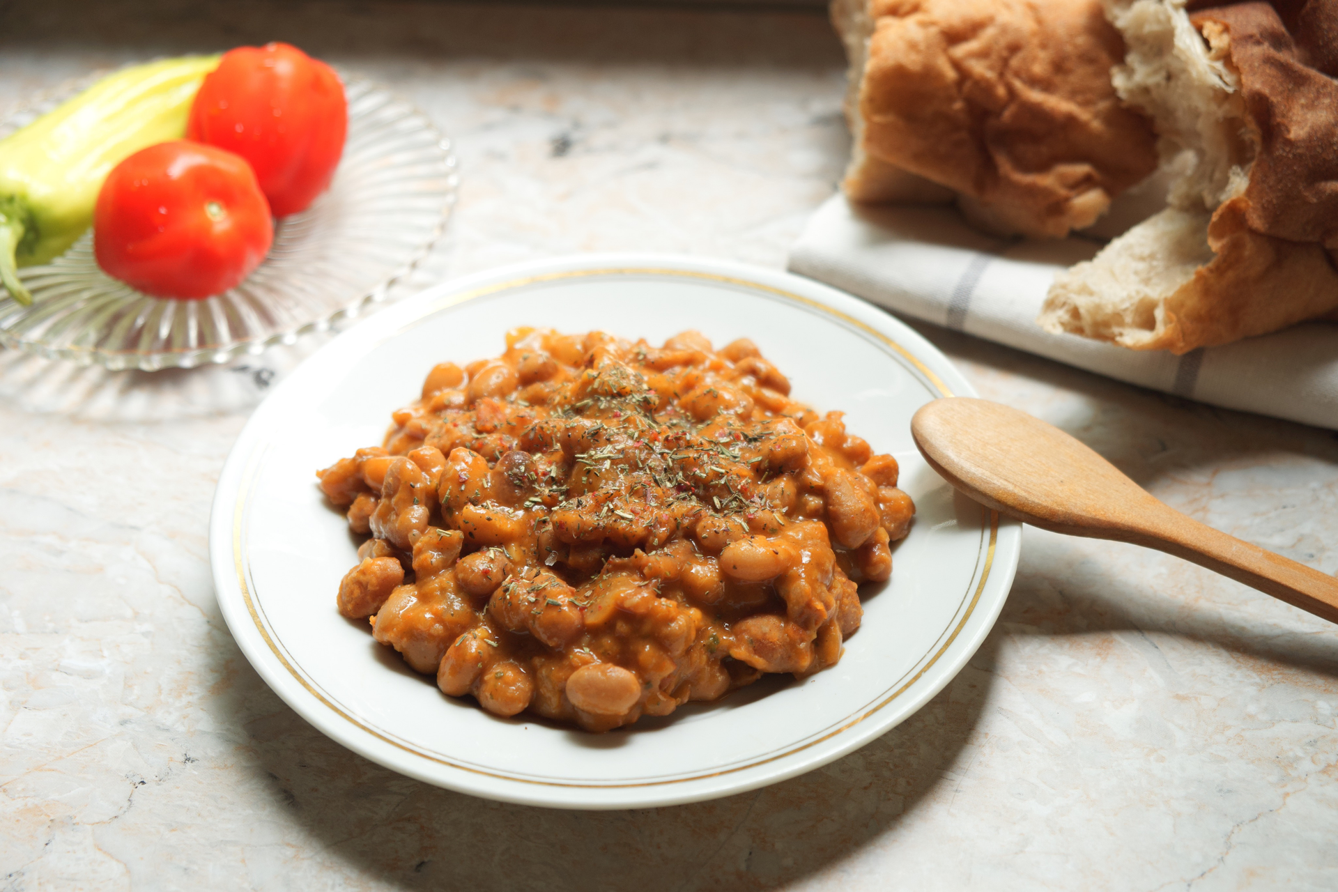 Overhead flat-lay of all ingredients for Savory Greek Fasolada with Garlic Bread Crumbles laid out on a kitchen surface.