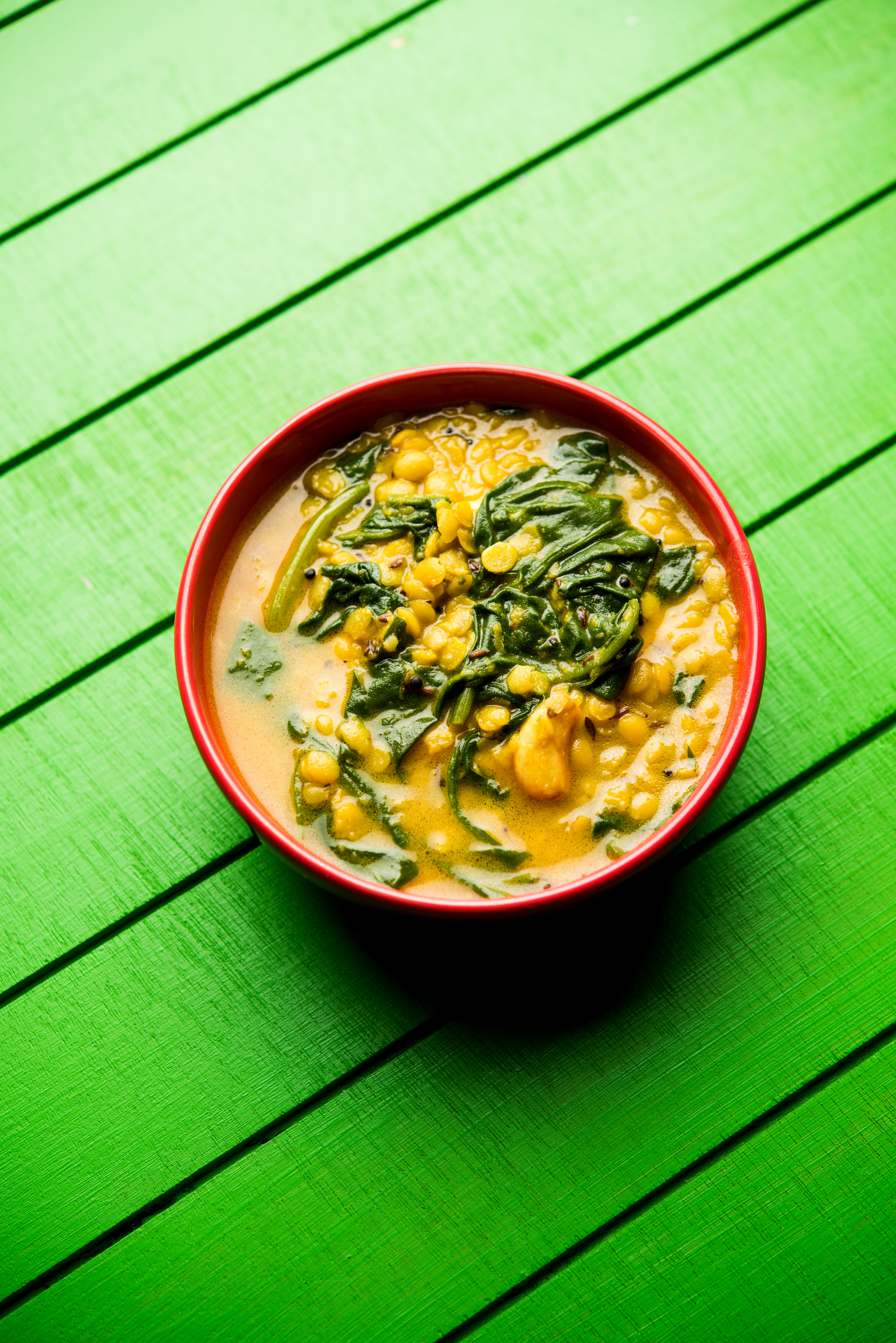 Overhead flat-lay of all ingredients for Savory Indian Moringa Leaf Dal with Coconut laid out on a kitchen surface.