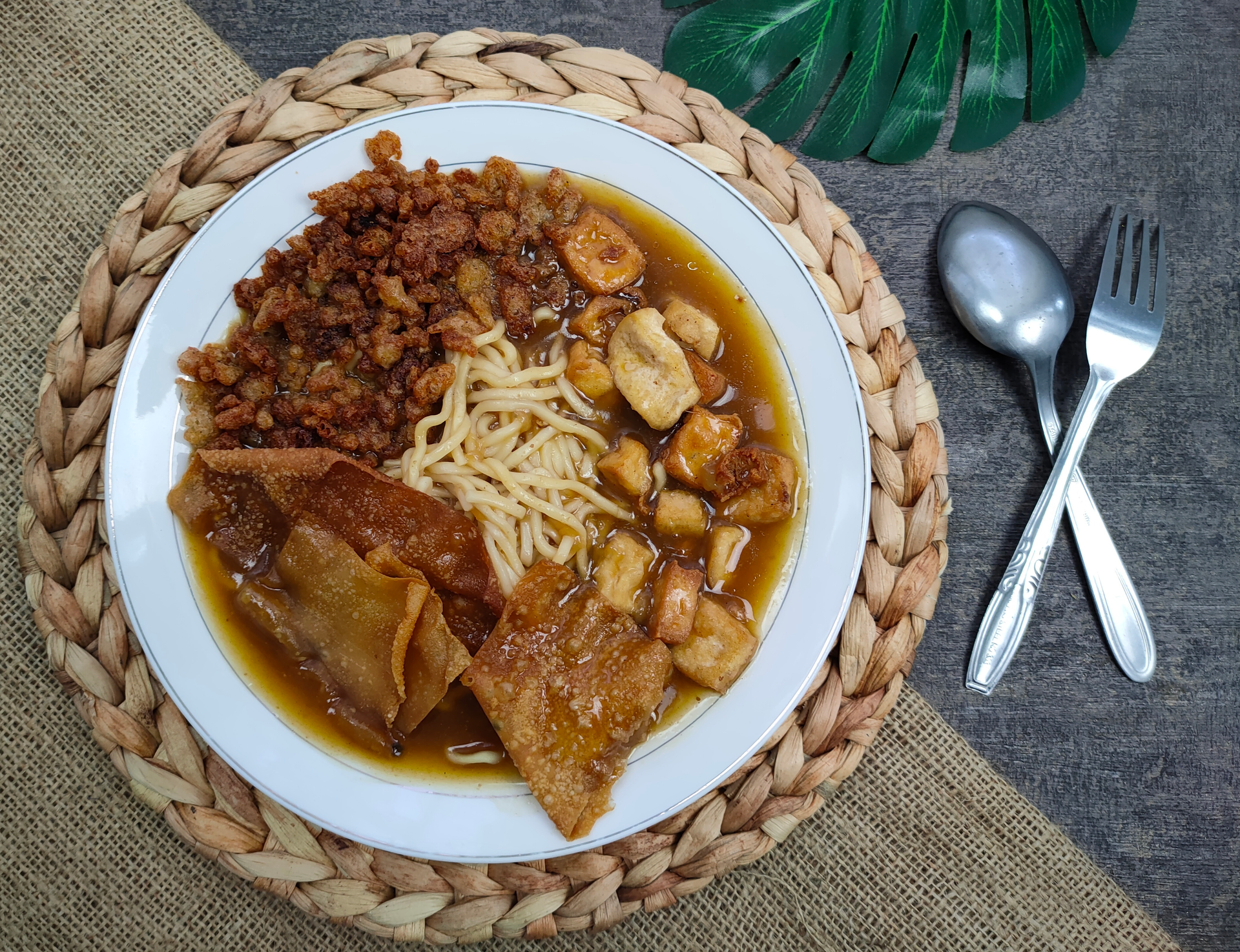 Overhead flat-lay of all ingredients for Savory Indonesian Gudeg with Jackfruit and Keluak laid out on a kitchen surface.
