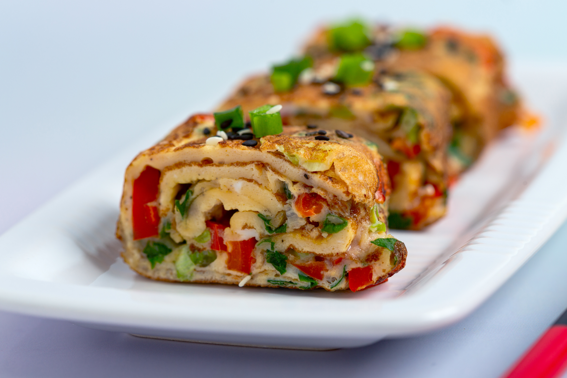 Savory Jamaican Ackee Roll-Ups with Saltfish and Scotch Bonnet Drizzle — Appetizer served and photographed from above