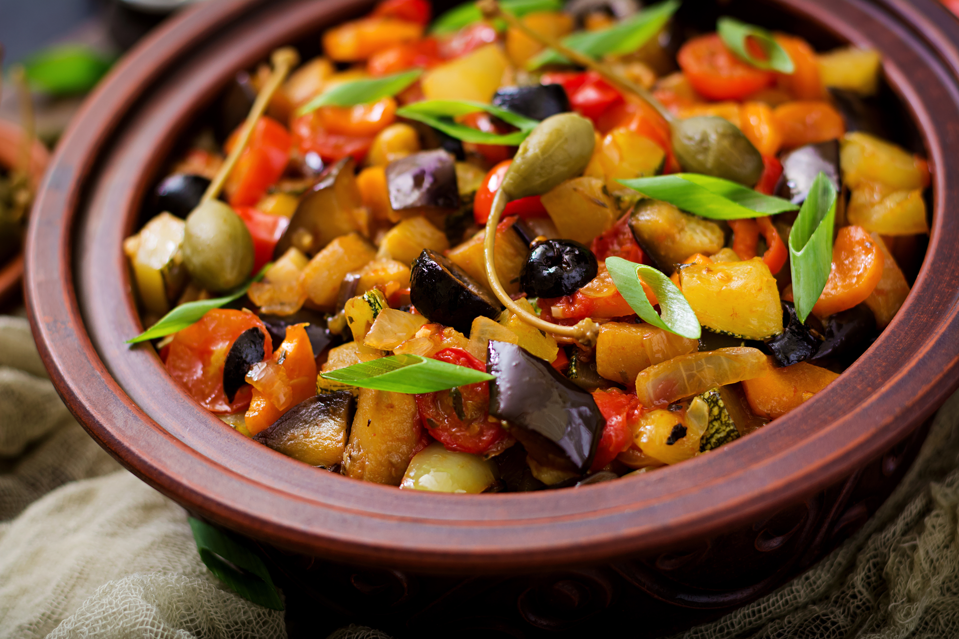 Overhead flat-lay of all ingredients for Savory Moroccan Eggplant and Chickpea Tajine with Preserved Lemon laid out on a kitchen surface.