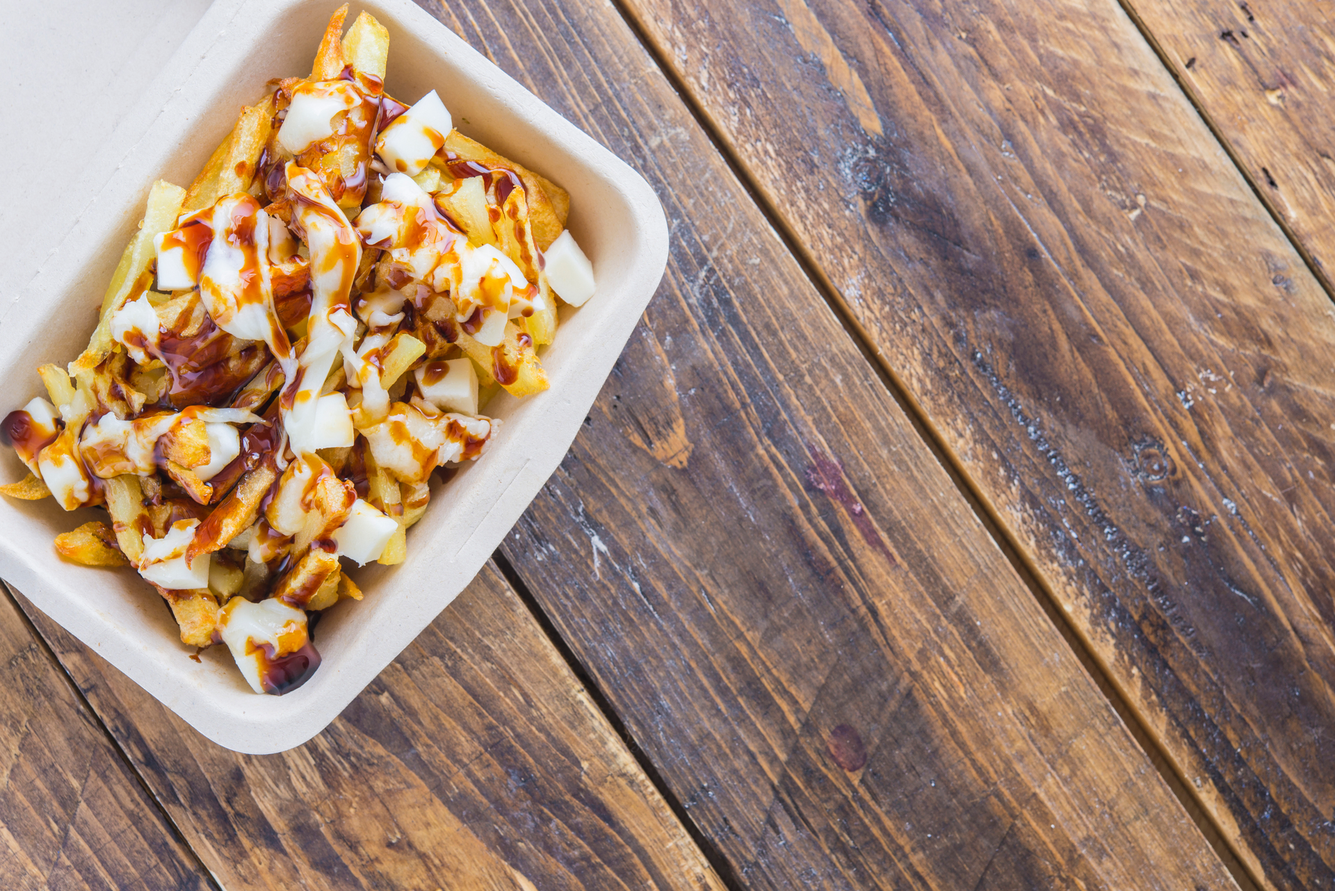 Overhead flat-lay of all ingredients for Silky Canadian Poutine laid out on a kitchen surface.