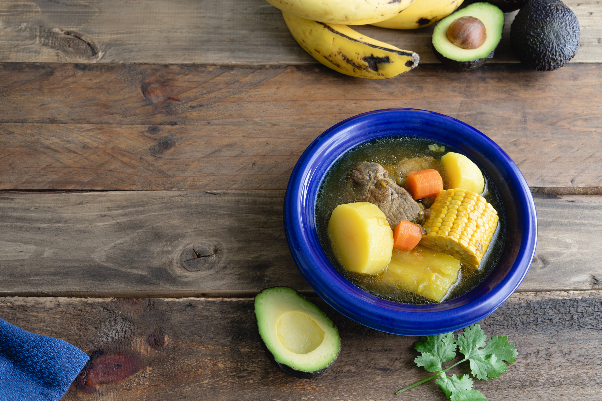 Overhead flat-lay of all ingredients for Silky Ecuadorian Aguado de Gallina with Potatoes and Avocado laid out on a kitchen surface.