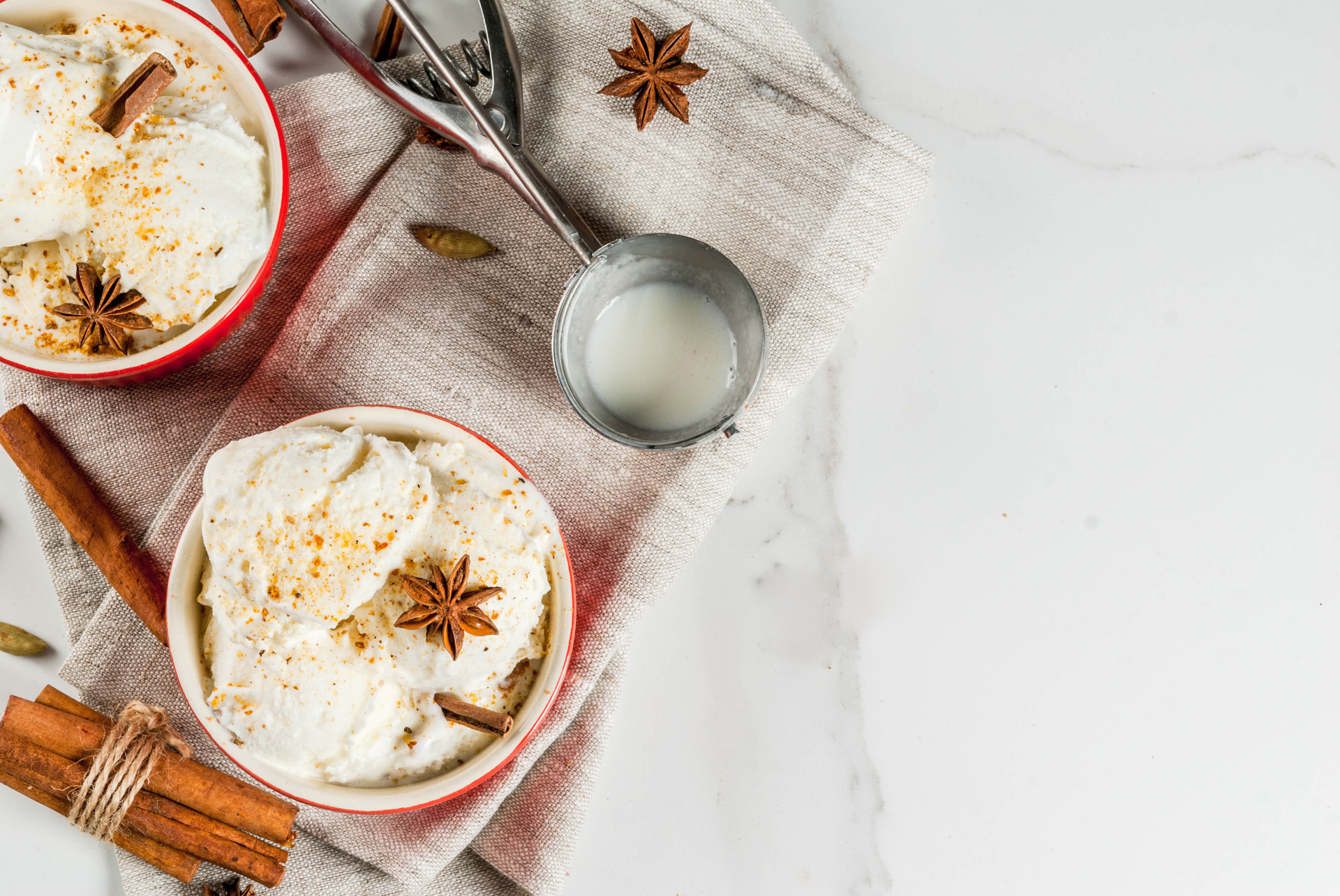 Overhead flat-lay of all ingredients for Silky Egyptian Roz Bel Laban with Cinnamon and Nutmeg laid out on a kitchen surface.