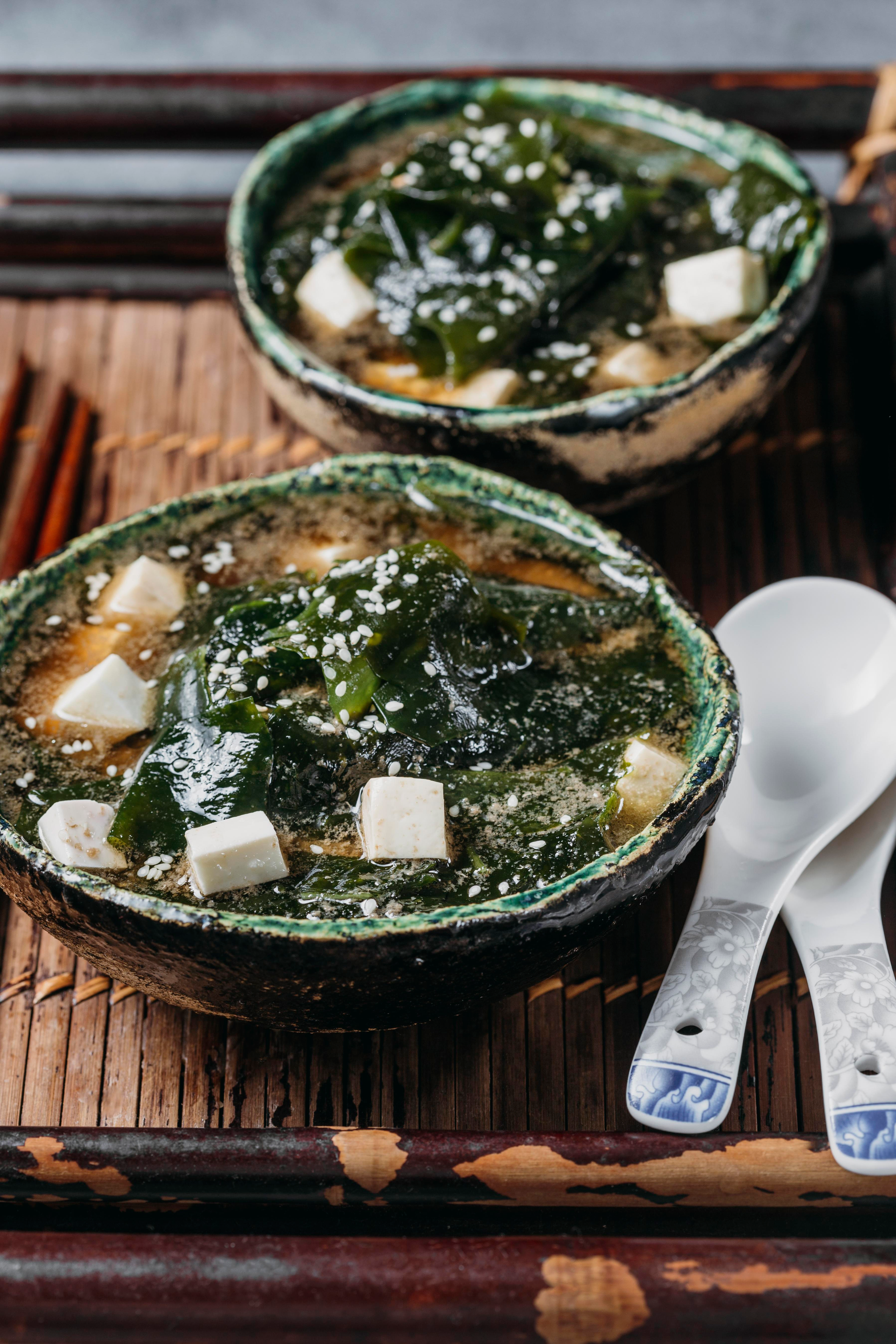 Overhead flat-lay of all ingredients for Silky Japanese Miso Soup with Seaweed and Tofu laid out on a kitchen surface.