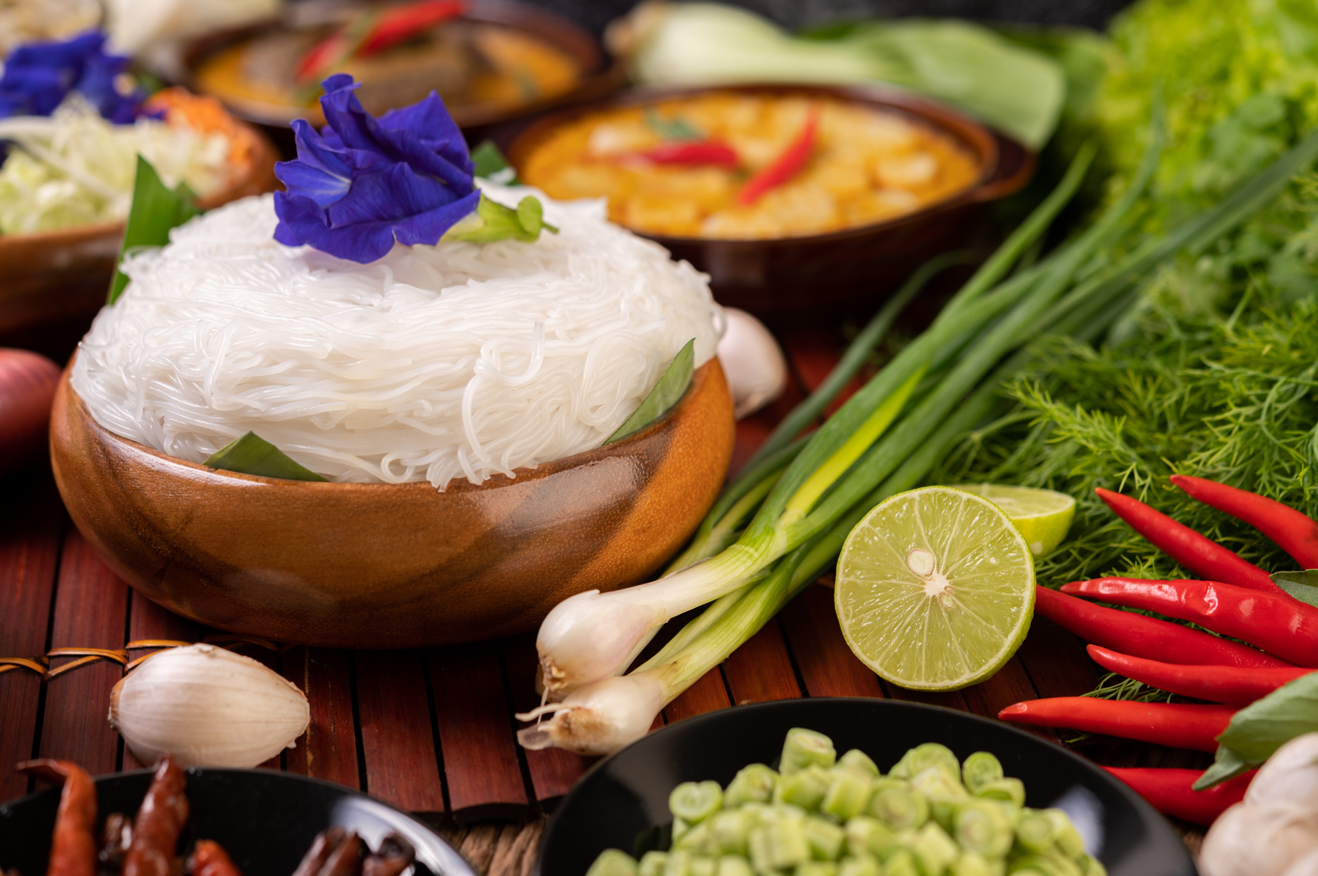 Overhead flat-lay of all ingredients for Silky Laos Khao Piak Sen with Fresh Herbs laid out on a kitchen surface.