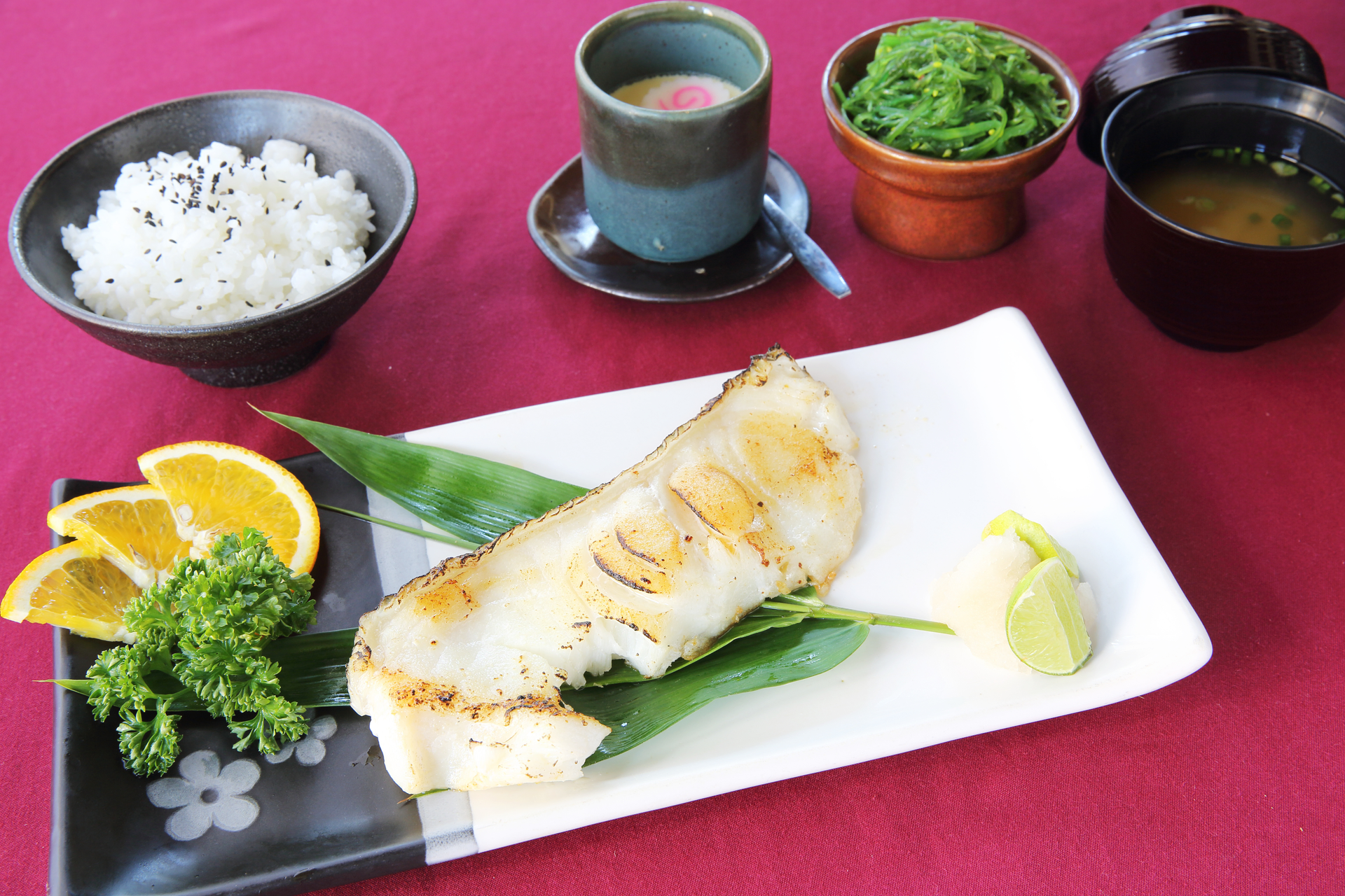 Overhead flat-lay of all ingredients for Sinanglay na Tilapia with Coconut Shallot Sauce laid out on a kitchen surface.