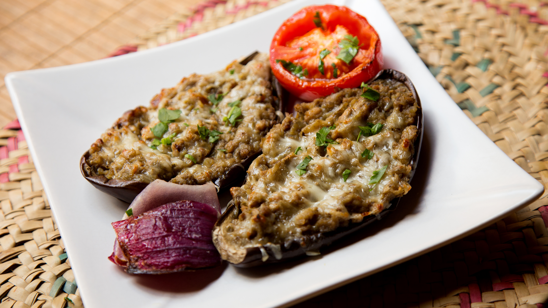 Overhead flat-lay of all ingredients for Smoky Indian Eggplant Bharta with Charred Scallions laid out on a kitchen surface.