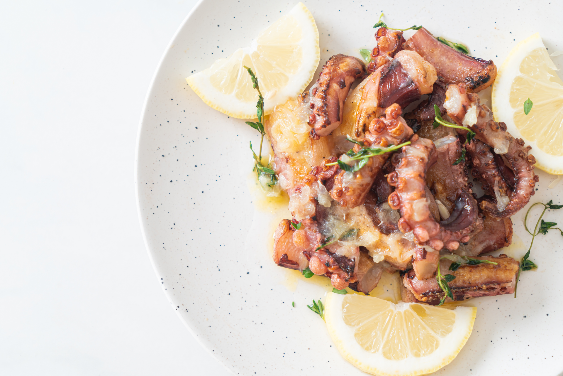 Overhead flat-lay of all ingredients for Smoky Spanish Pulpo a la Plancha with Garlic Aioli laid out on a kitchen surface.
