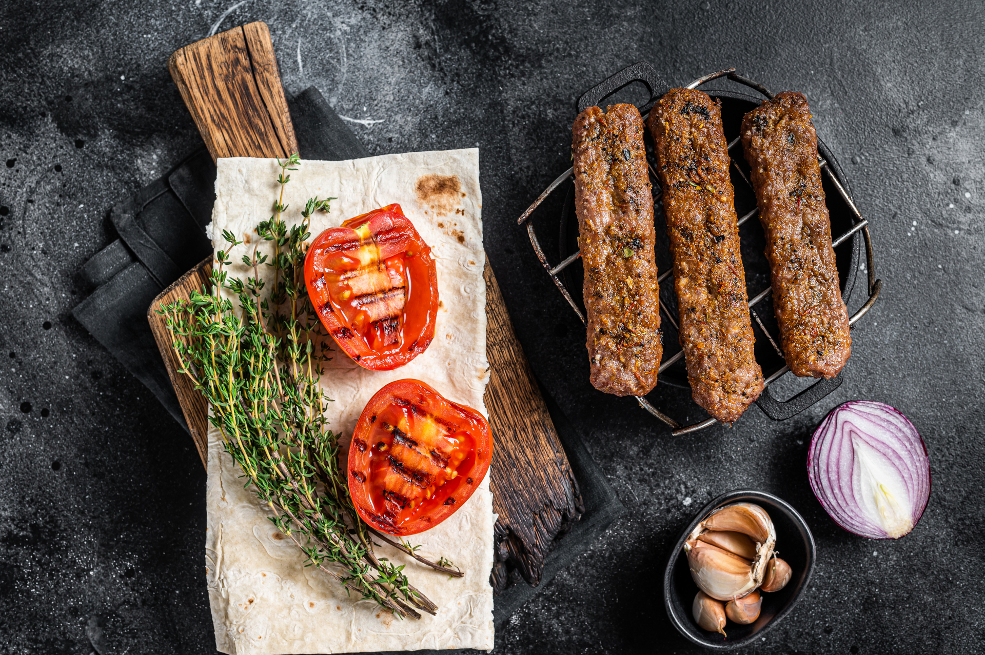 Overhead flat-lay of all ingredients for Smoky Turkish Testi Kebab laid out on a kitchen surface.