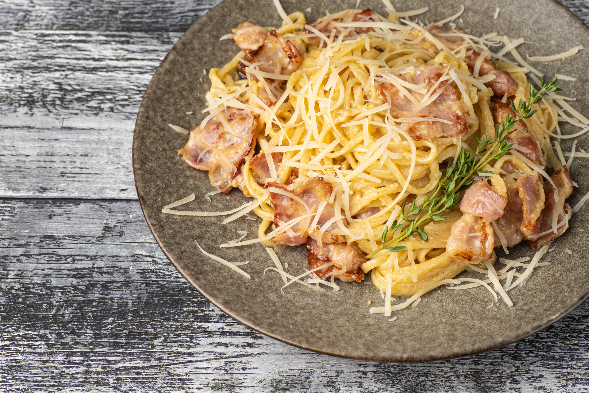 Overhead flat-lay of all ingredients for Spaghetti Carbonara laid out on a kitchen surface.
