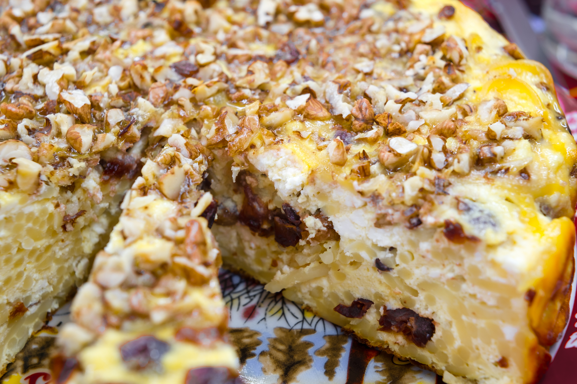 Spanish Manchego Tart with Crushed Almond and Honey Drizzle — Appetizer served and photographed from above