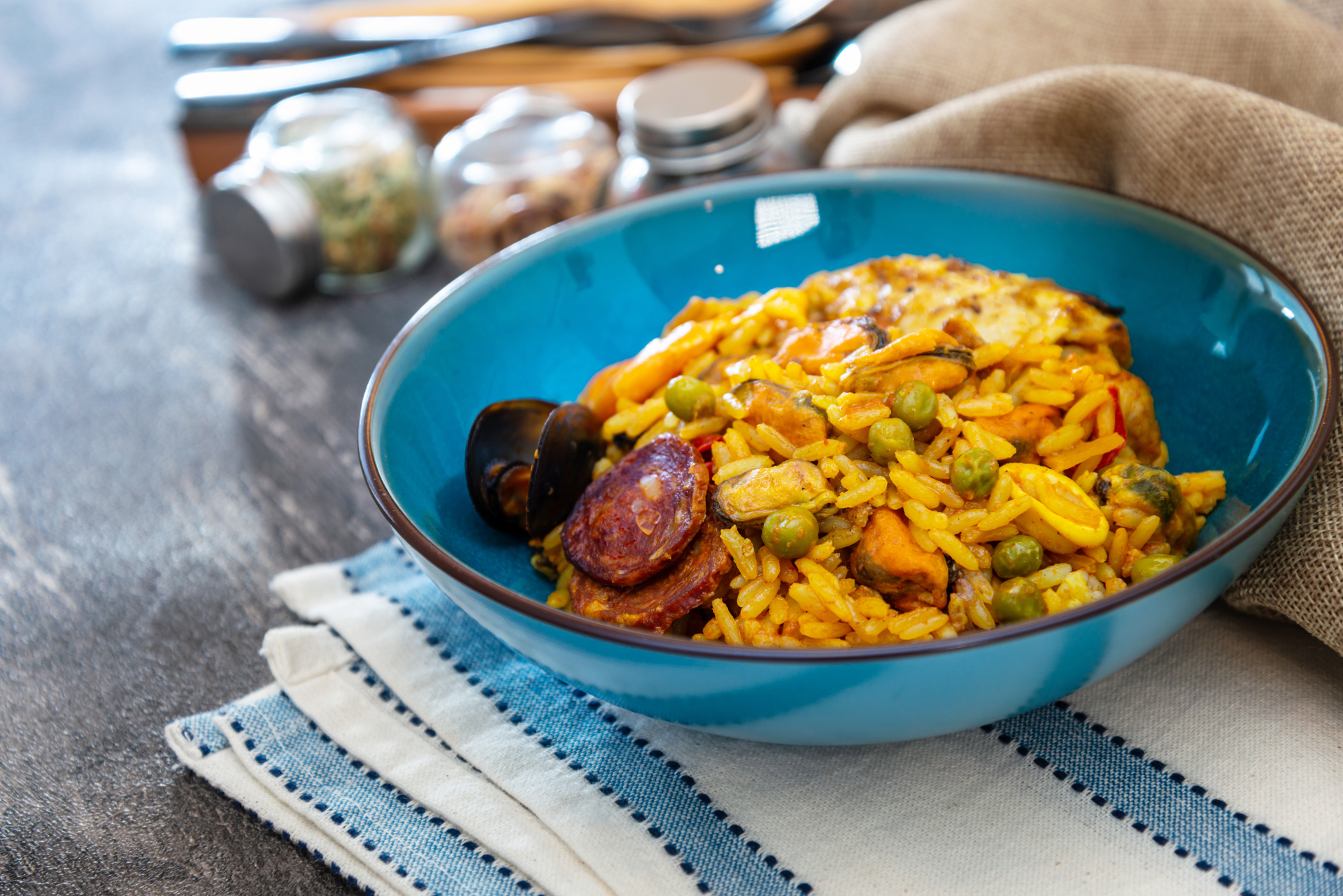 Overhead flat-lay of all ingredients for Spanish Vermicelli Paella with Saffron and Chorizo laid out on a kitchen surface.