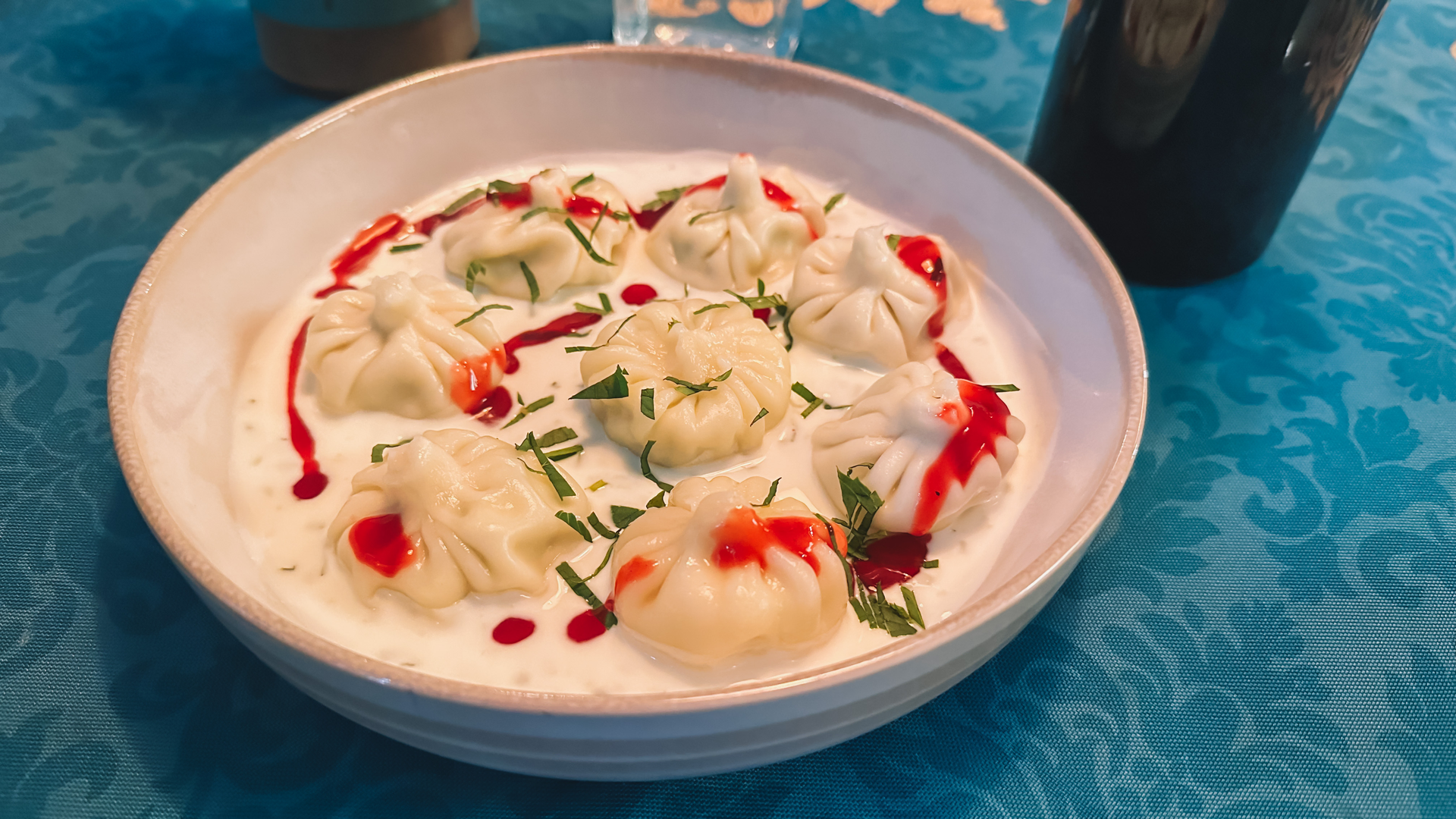 Overhead flat-lay of all ingredients for Spiced Afghan Mantu Dumplings with Tomato Yogurt Sauce laid out on a kitchen surface.