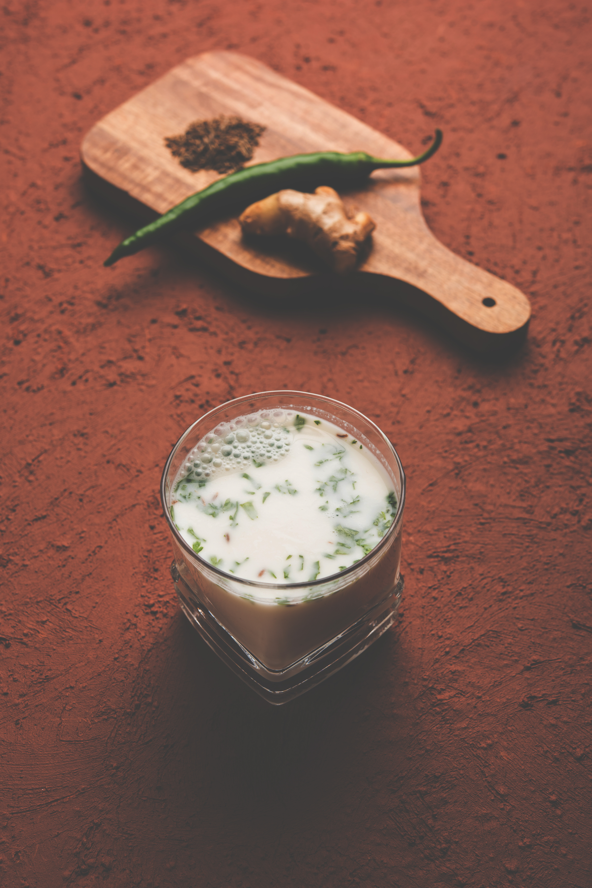 Overhead flat-lay of all ingredients for Spiced Balkan Ayran with Sumac and Cucumber laid out on a kitchen surface.