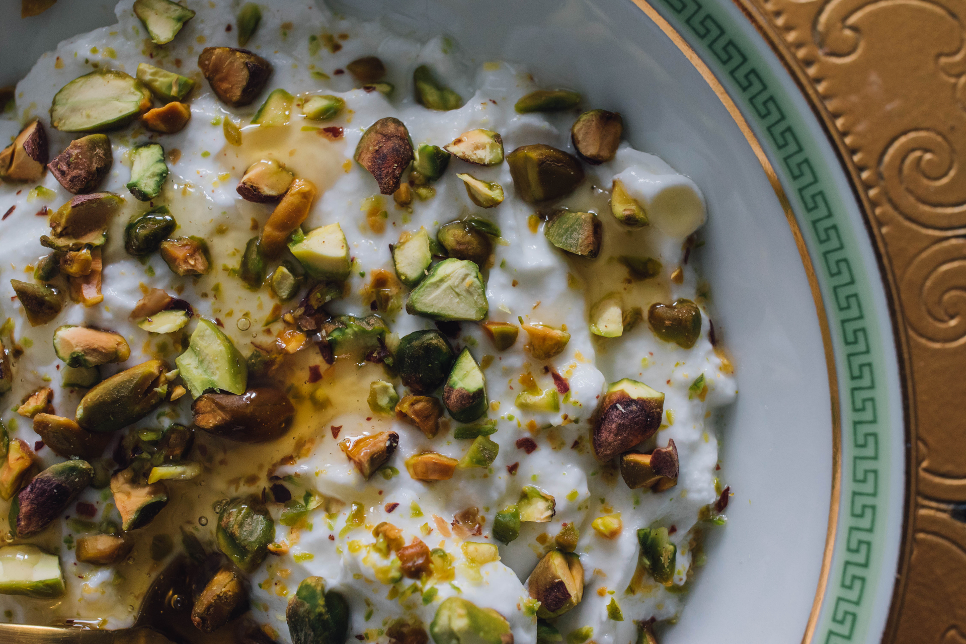 Overhead flat-lay of all ingredients for Spiced Egyptian Roz Bel Laban with Cardamom and Pistachios laid out on a kitchen surface.