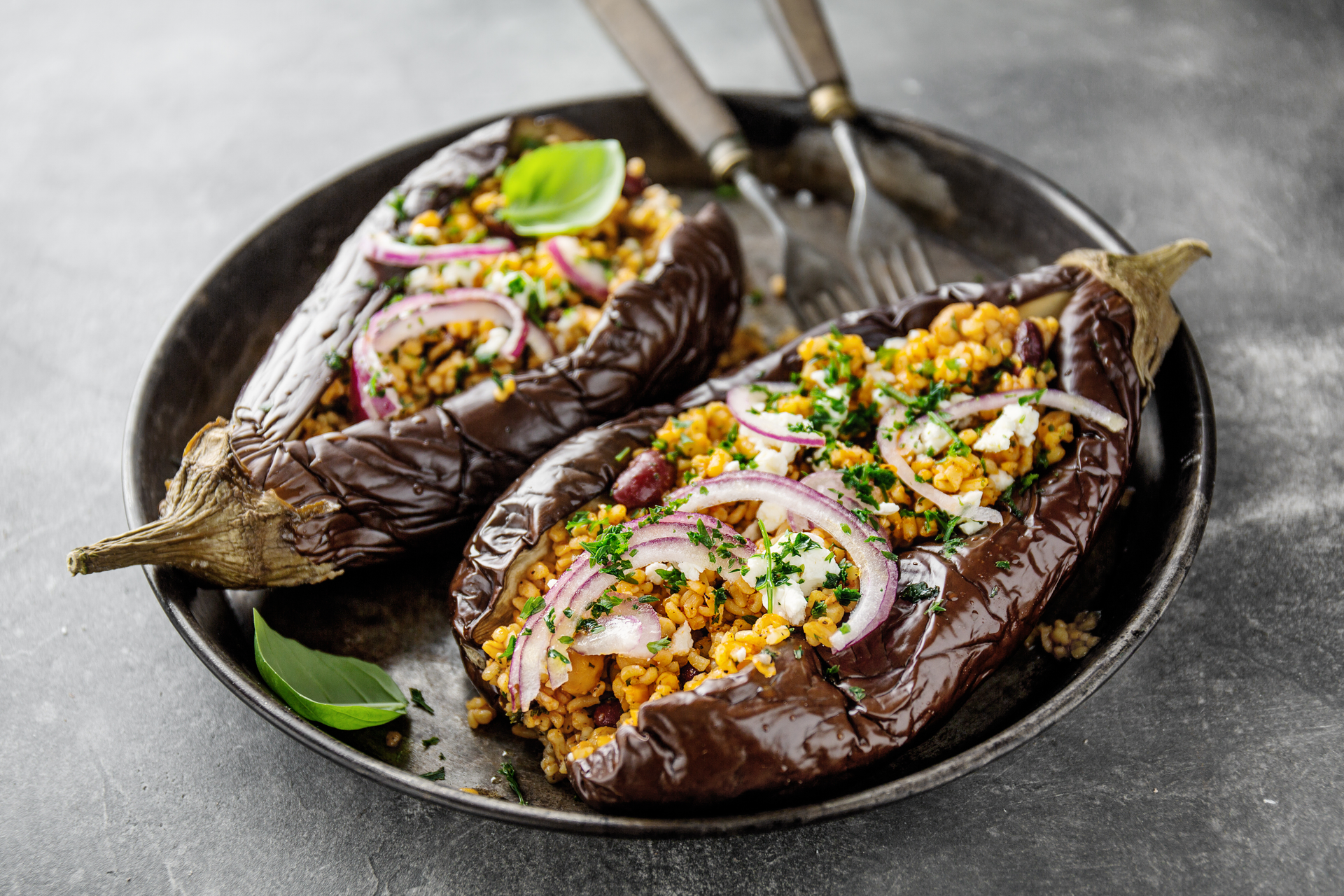 Overhead flat-lay of all ingredients for Spiced Indian Eggplant Bharta with Charred Onions laid out on a kitchen surface.