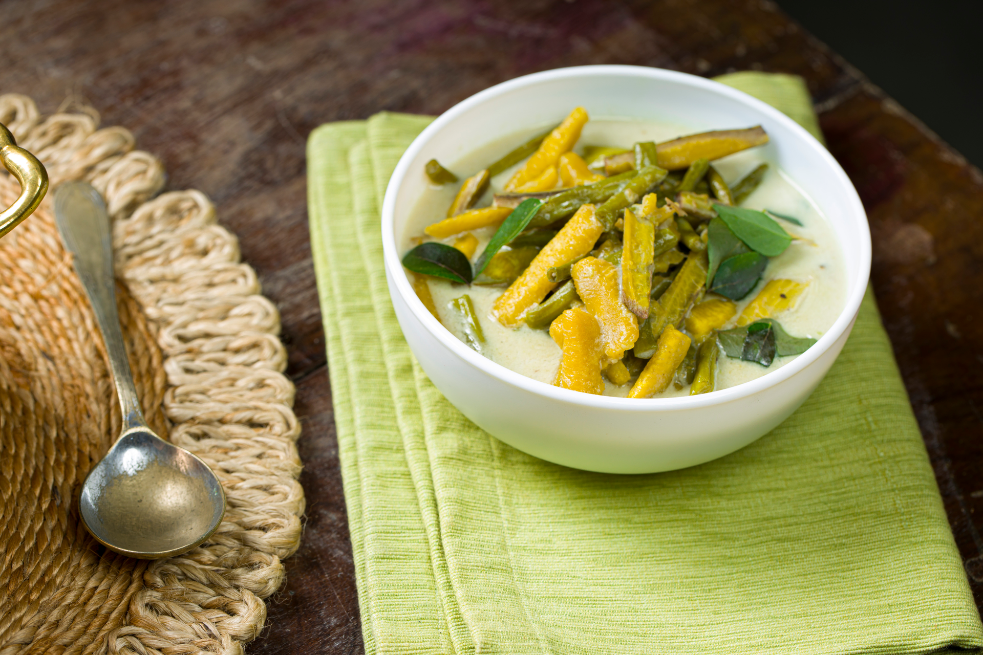 Overhead flat-lay of all ingredients for Spiced Indonesian Lodeh with Tempeh and Long Beans laid out on a kitchen surface.
