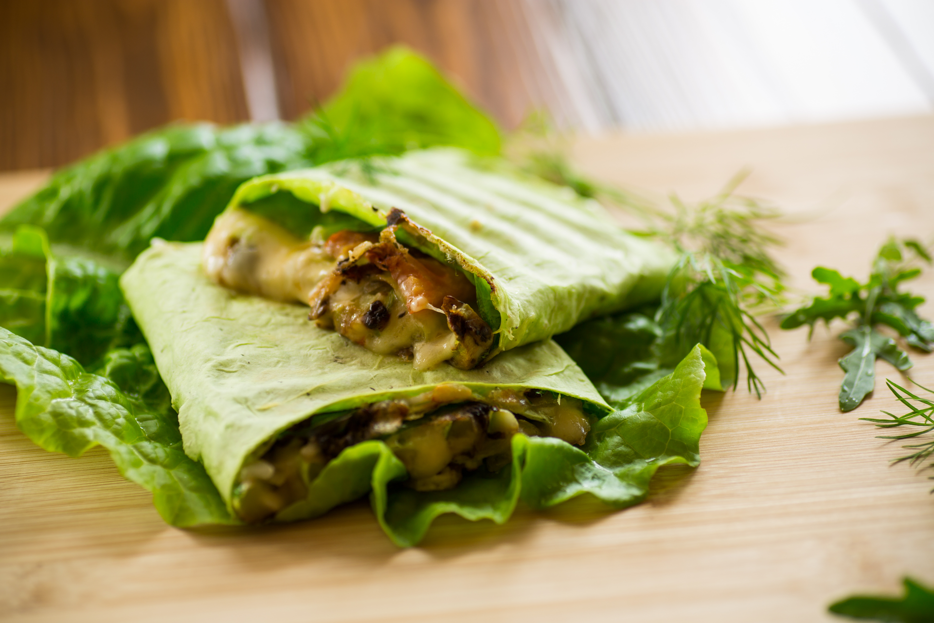 Overhead flat-lay of all ingredients for Spiced Kenyan Sukuma Wiki Wraps with Peanut Sauce laid out on a kitchen surface.