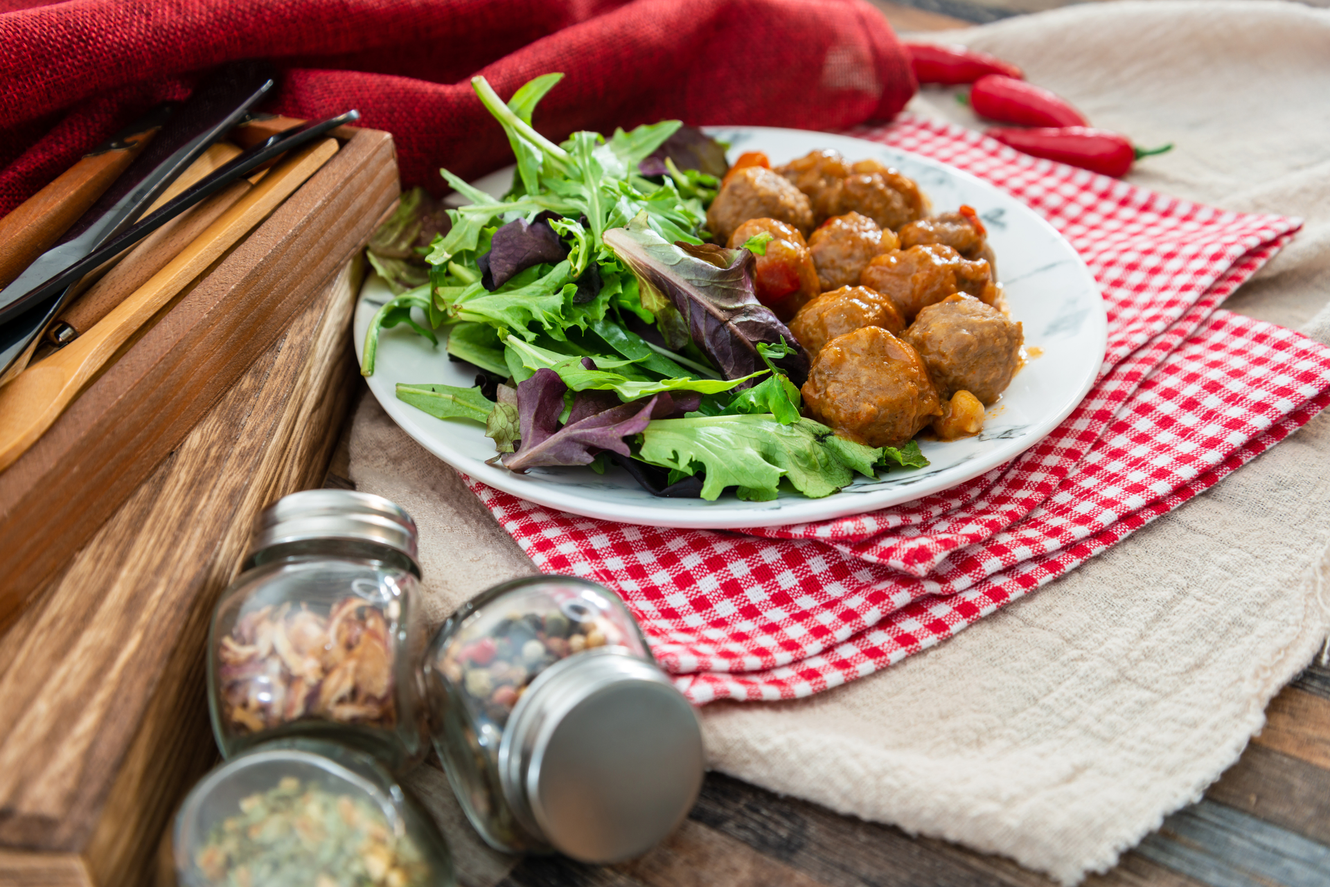 Overhead flat-lay of all ingredients for Spiced Tunisian Harissa-Infused Meatballs with Chickpea Salad laid out on a kitchen surface.