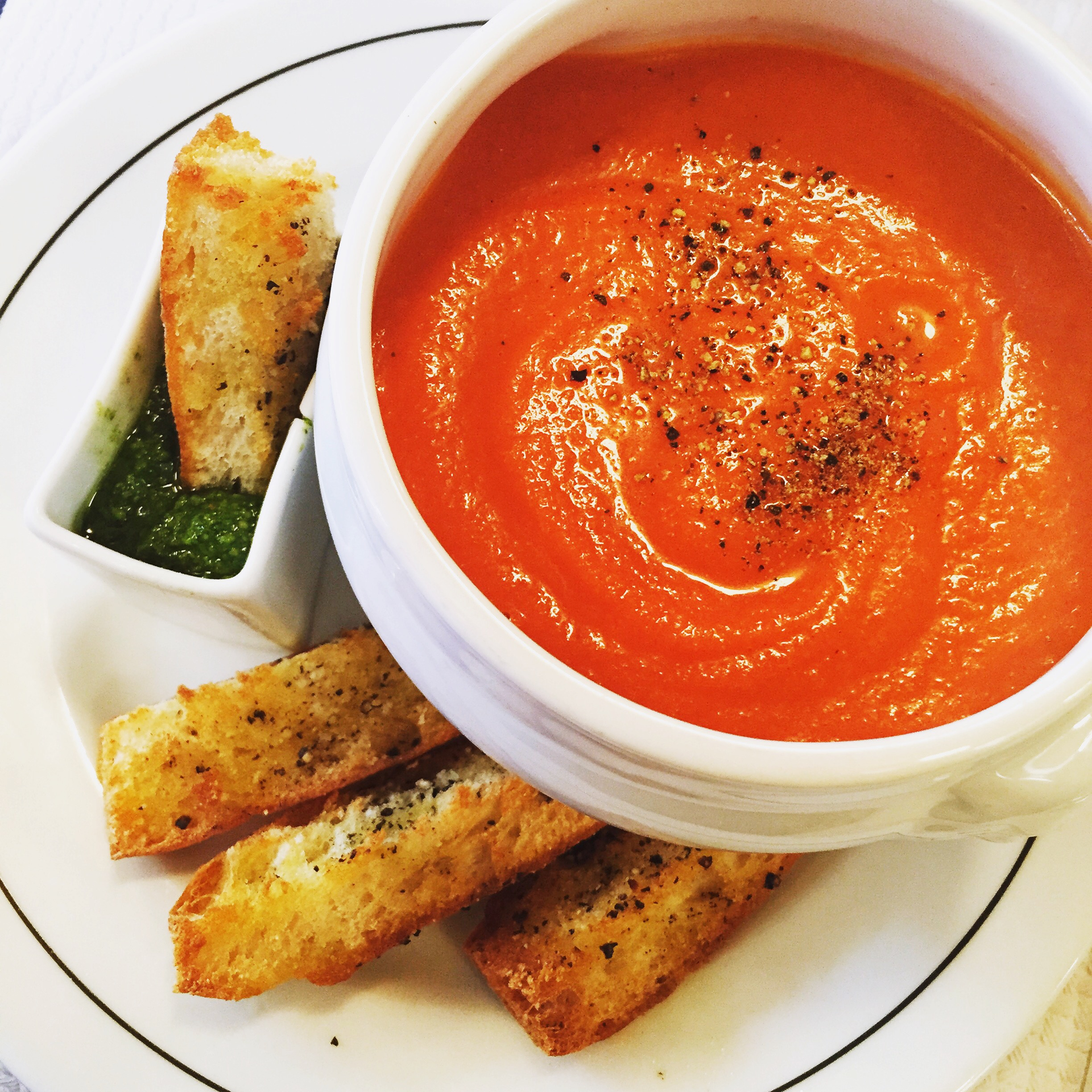 Overhead flat-lay of all ingredients for Spicy Cajun Tomato Bisque with Creole Croutons laid out on a kitchen surface.