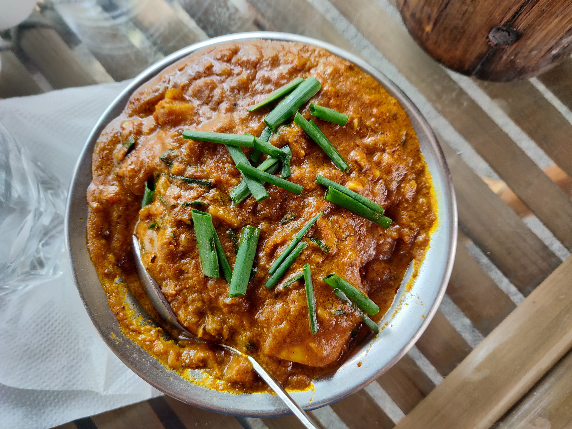 Overhead flat-lay of all ingredients for Spicy Caribbean Curry Goat with Scallions and Thyme laid out on a kitchen surface.