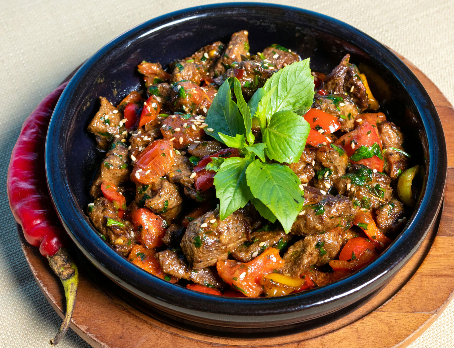 Overhead flat-lay of all ingredients for Spicy Caribbean Goat Pepperpot with Cassareep and Sorrel laid out on a kitchen surface.