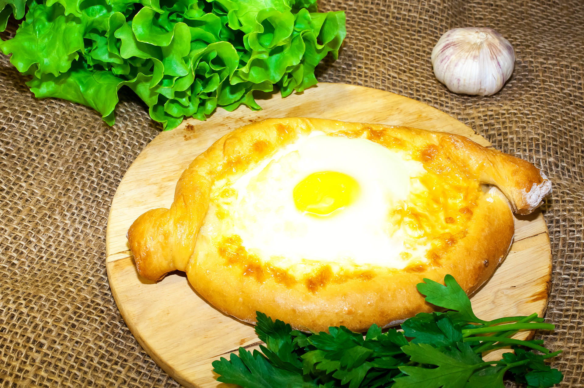 Overhead flat-lay of all ingredients for Spicy Georgian Adjarian Khachapuri with Runny Egg laid out on a kitchen surface.