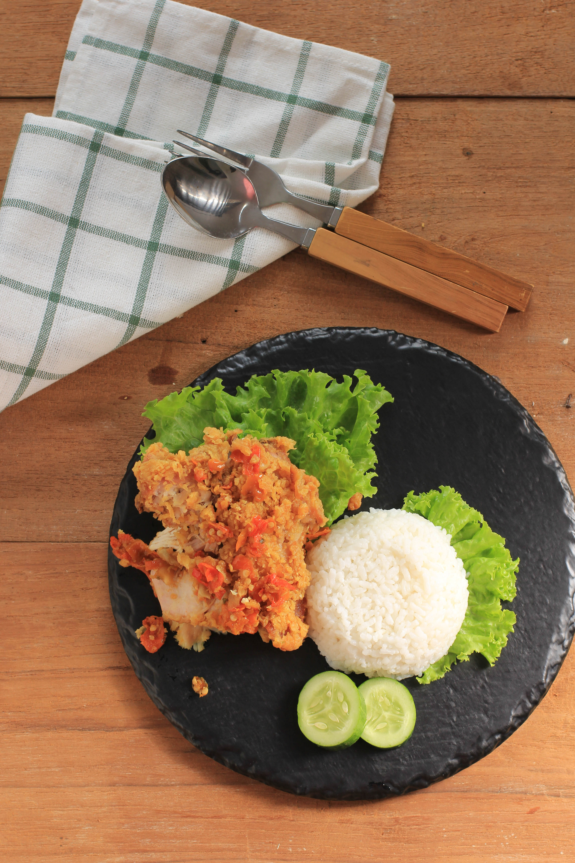Overhead flat-lay of all ingredients for Spicy Indonesian Ayam Geprek with Sambal laid out on a kitchen surface.