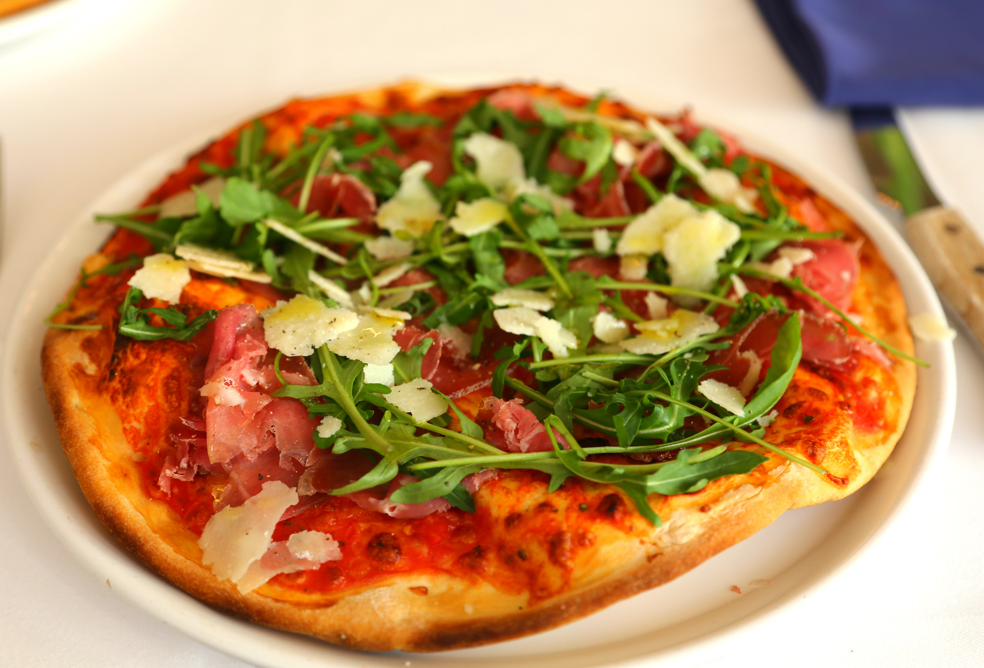 Overhead flat-lay of all ingredients for Spicy Italian Calabrian 'Nduja Pizza with Burrata and Arugula laid out on a kitchen surface.