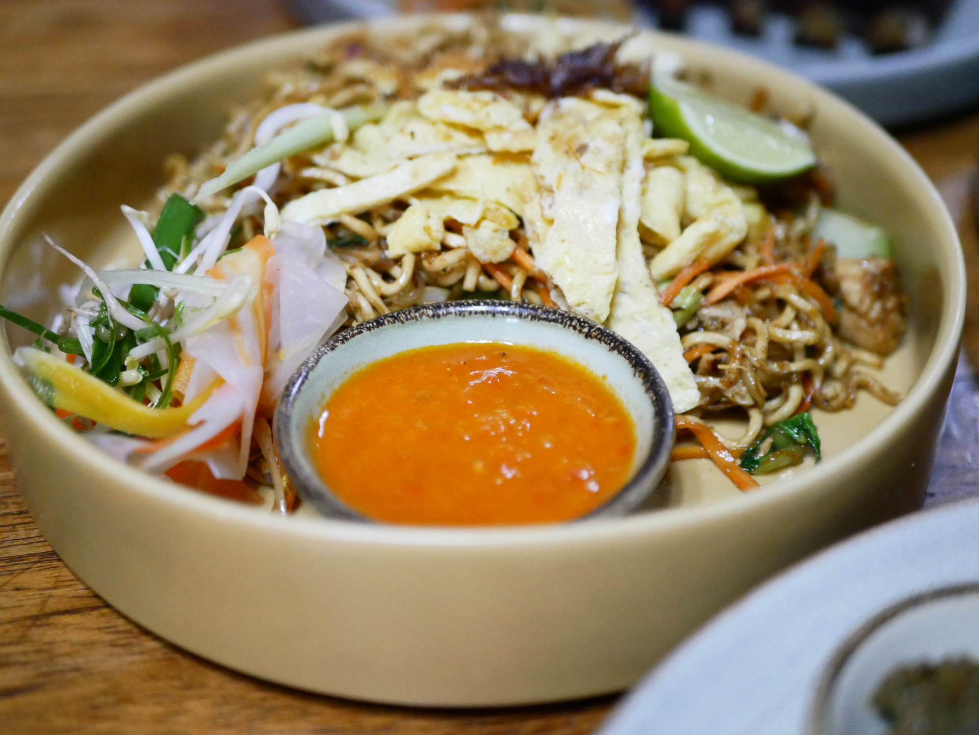 Overhead flat-lay of all ingredients for Spicy Malaysian Asam Laksa with Tamarind Fish Broth laid out on a kitchen surface.