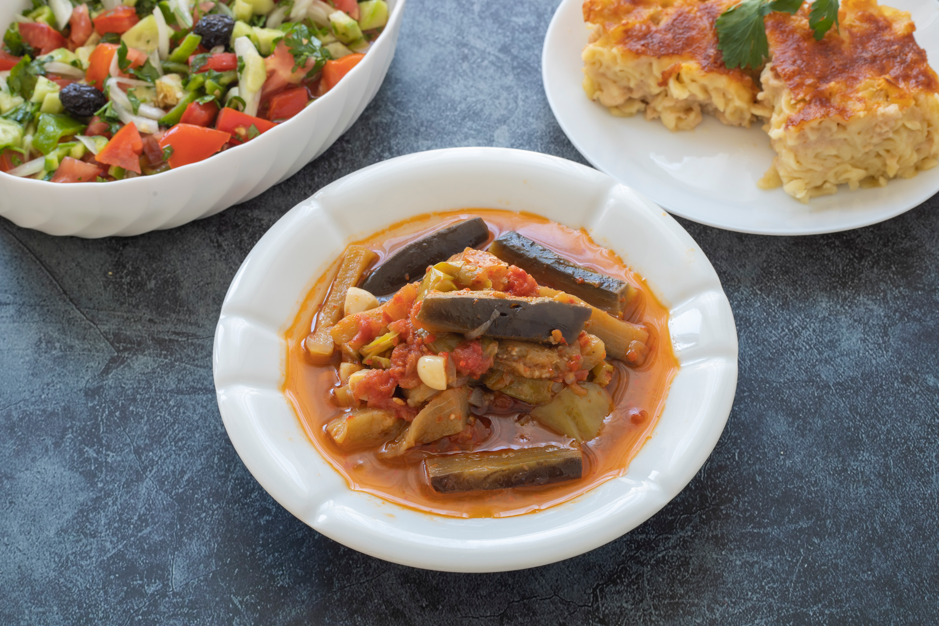 Overhead flat-lay of all ingredients for Spicy Moroccan Zaalouk with Eggplant and Tomatoes laid out on a kitchen surface.