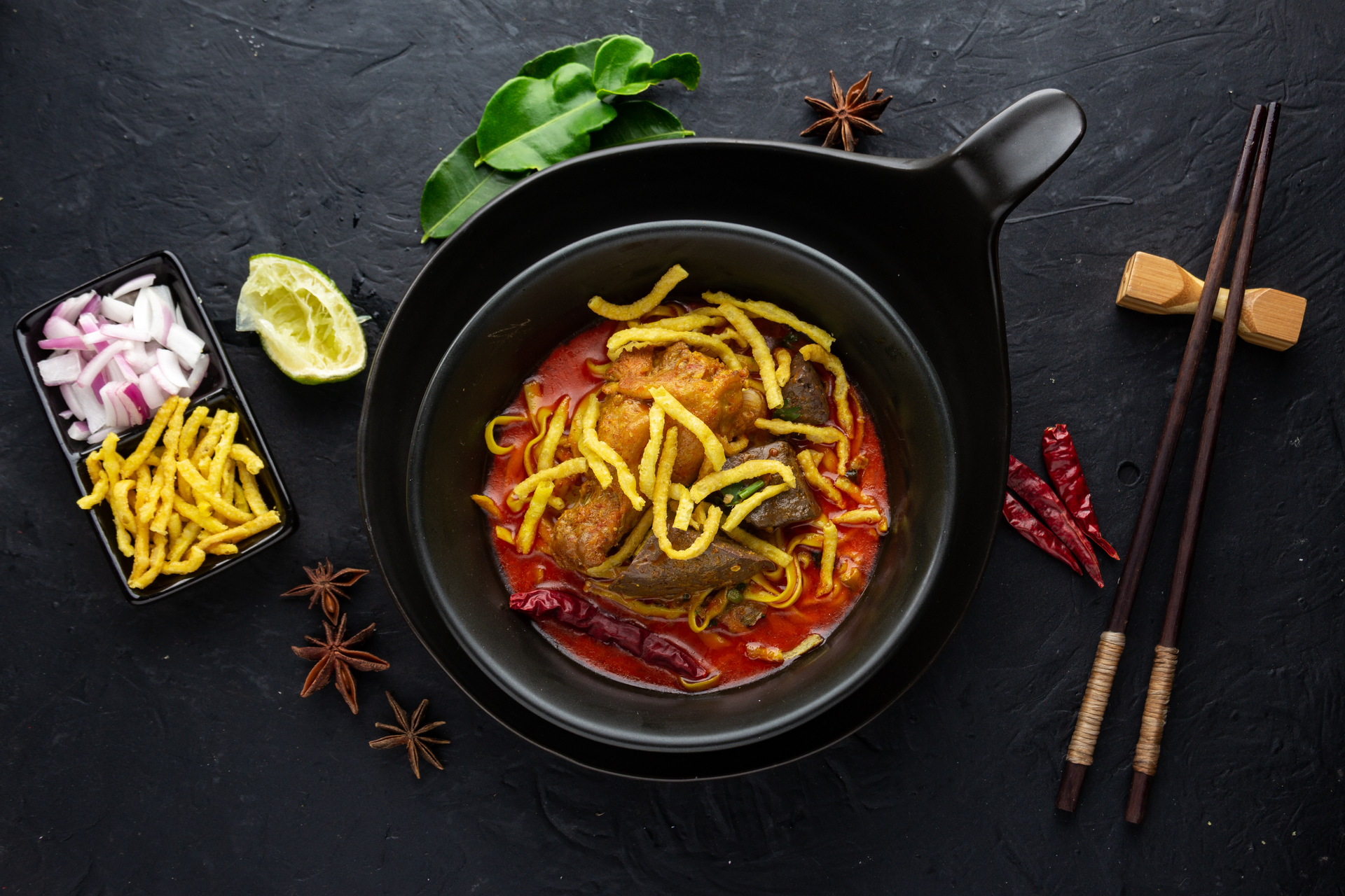 Overhead flat-lay of all ingredients for Spicy Nepali Thukpa with Chilli and Chicken laid out on a kitchen surface.