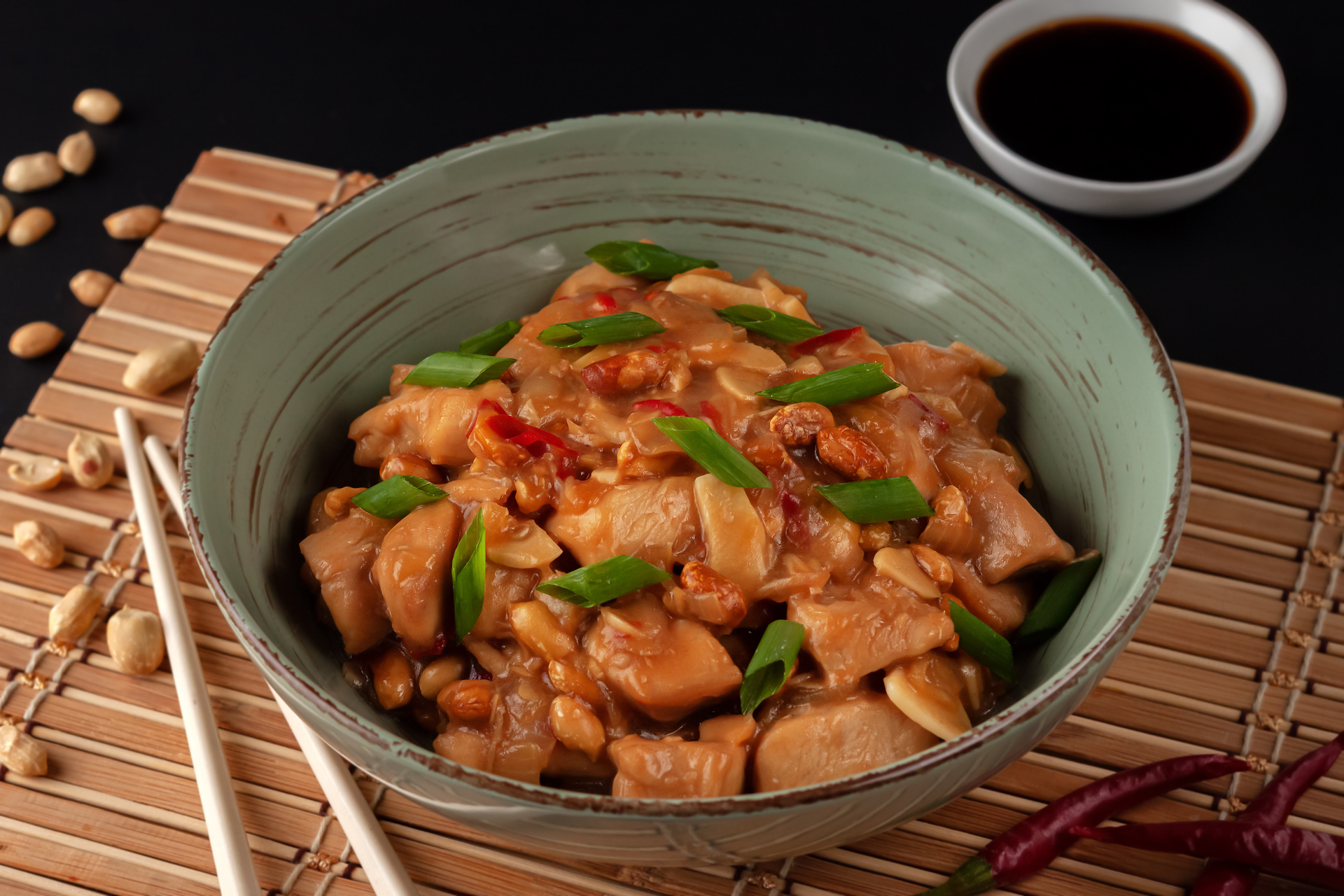 Overhead flat-lay of all ingredients for Spicy Sichuan Kung Pao Chicken with Peanuts laid out on a kitchen surface.