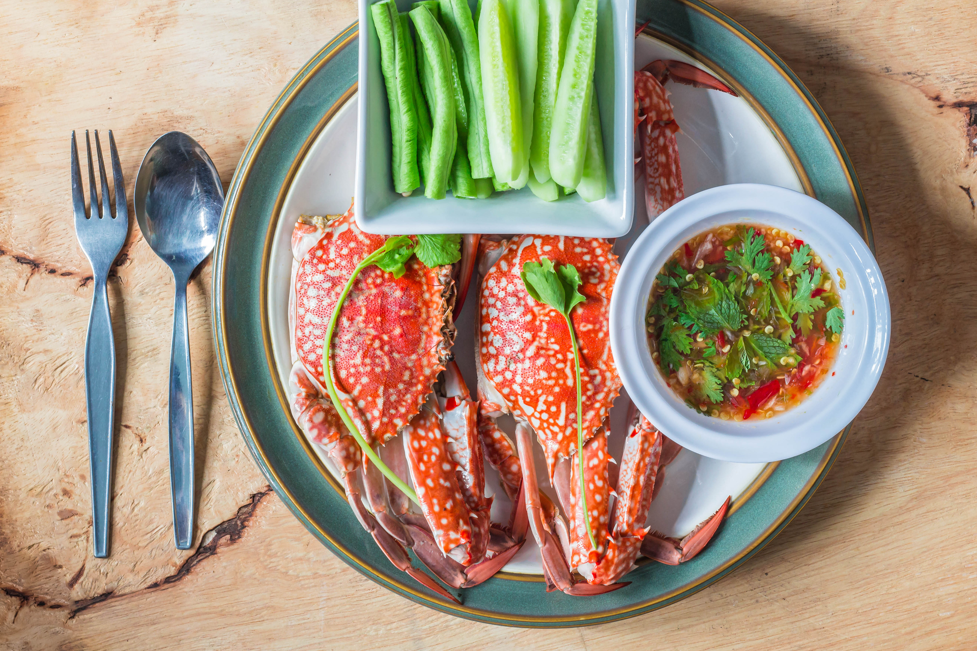 Overhead flat-lay of all ingredients for Spicy Singaporean Chili Crab with Lime laid out on a kitchen surface.