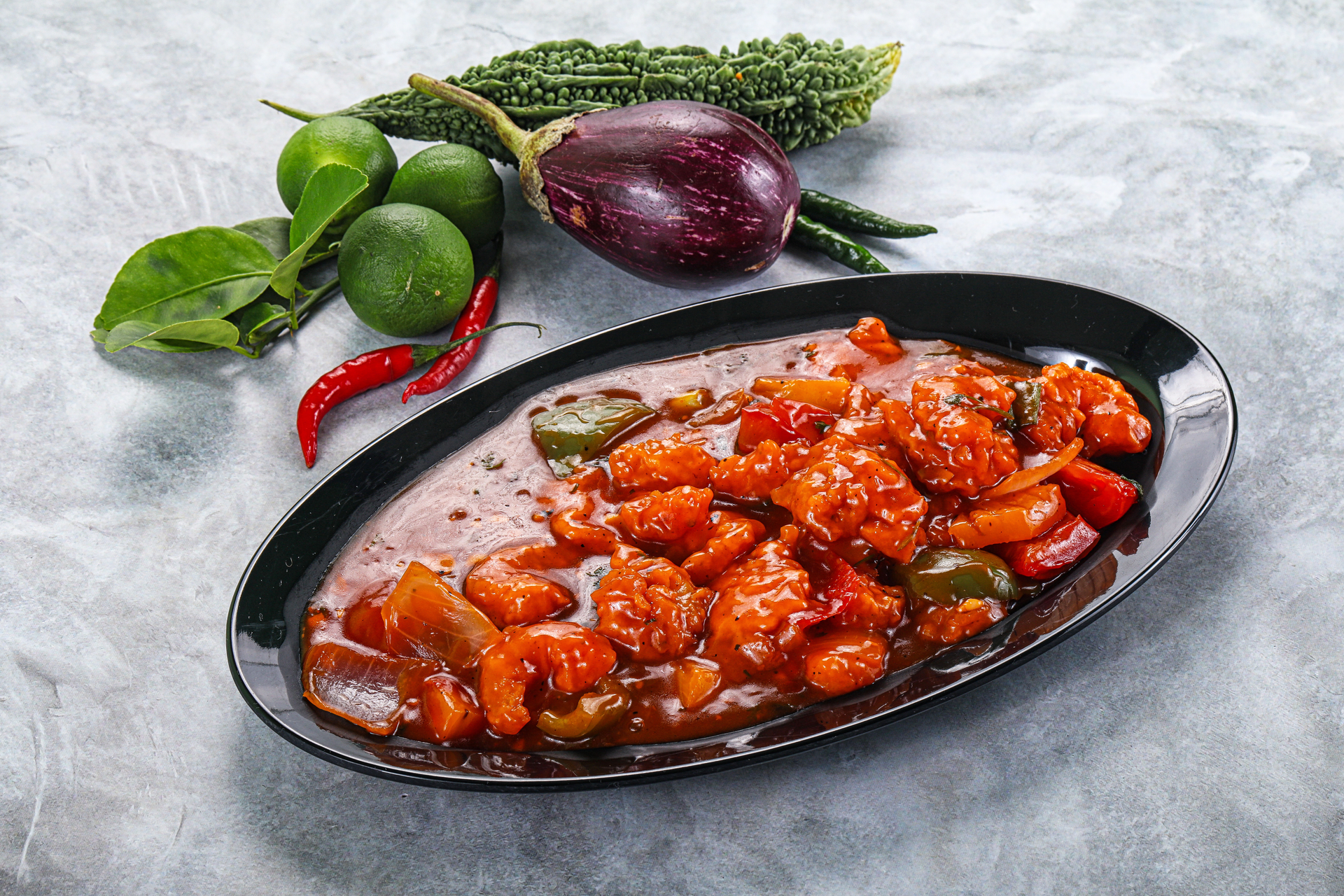Overhead flat-lay of all ingredients for Spicy Singaporean Sambal Eggplant with Fried Basil Leaves laid out on a kitchen surface.