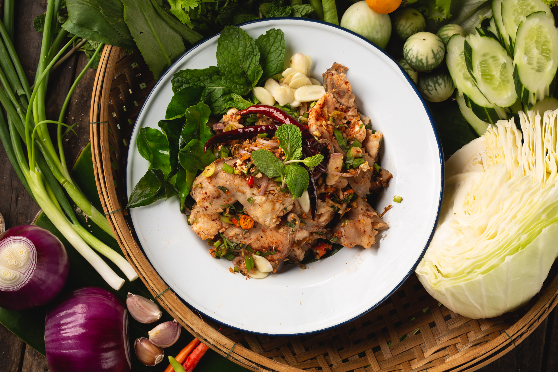 Overhead flat-lay of all ingredients for Spicy Thai Tamarind Duck with Fresh Basil laid out on a kitchen surface.