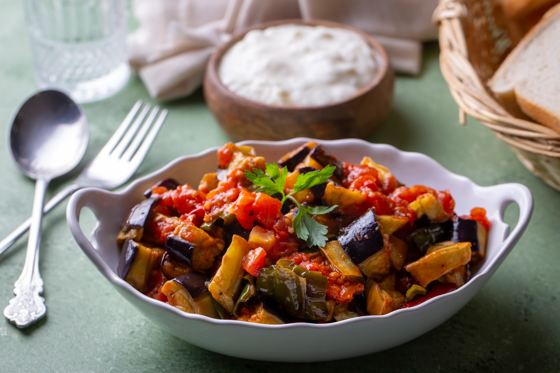 Overhead flat-lay of all ingredients for Spicy Tunisian Eggplant Casserole with Harissa and Mint laid out on a kitchen surface.