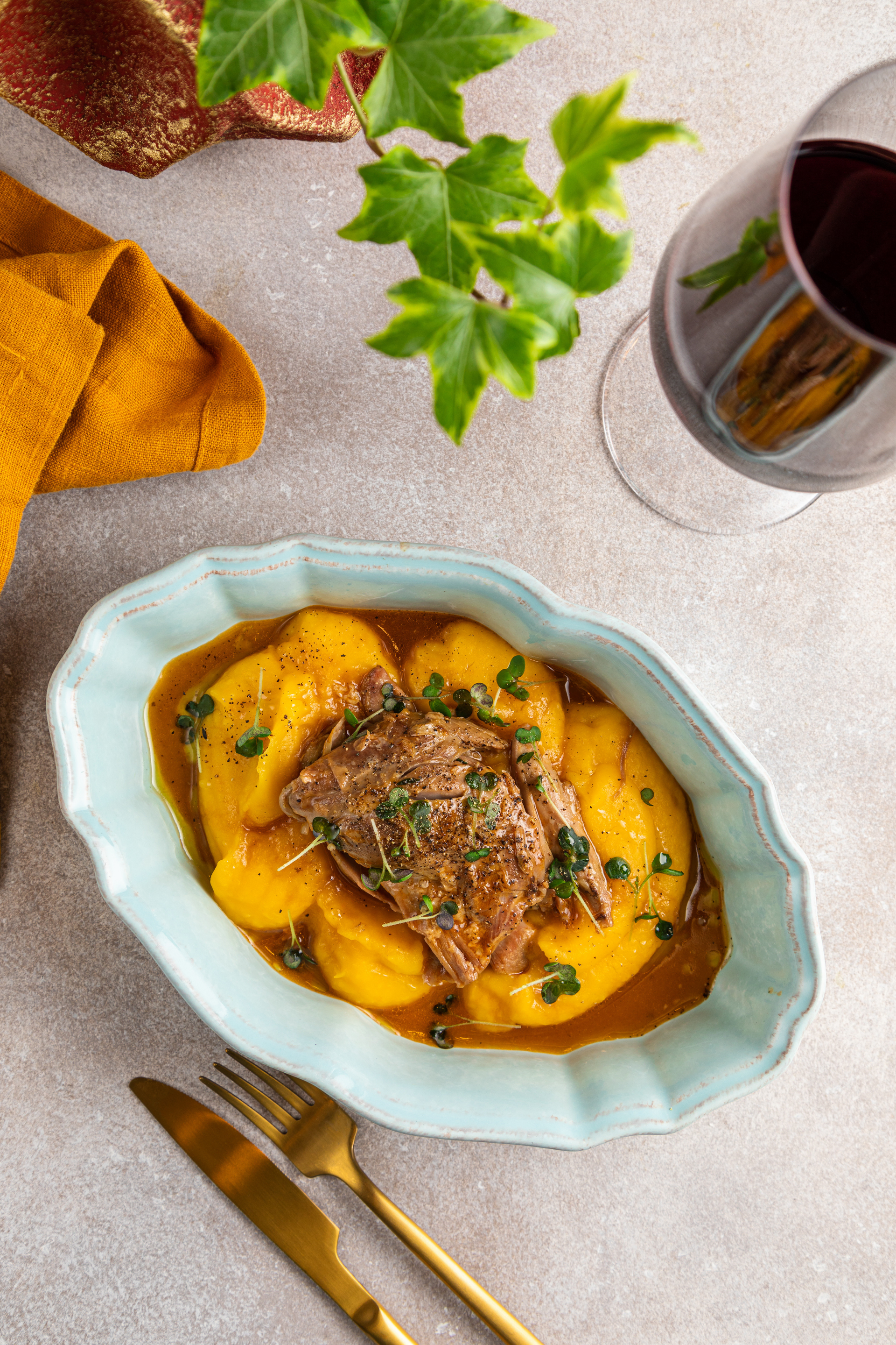 Overhead flat-lay of all ingredients for Stracotto al Barolo with Polenta laid out on a kitchen surface.