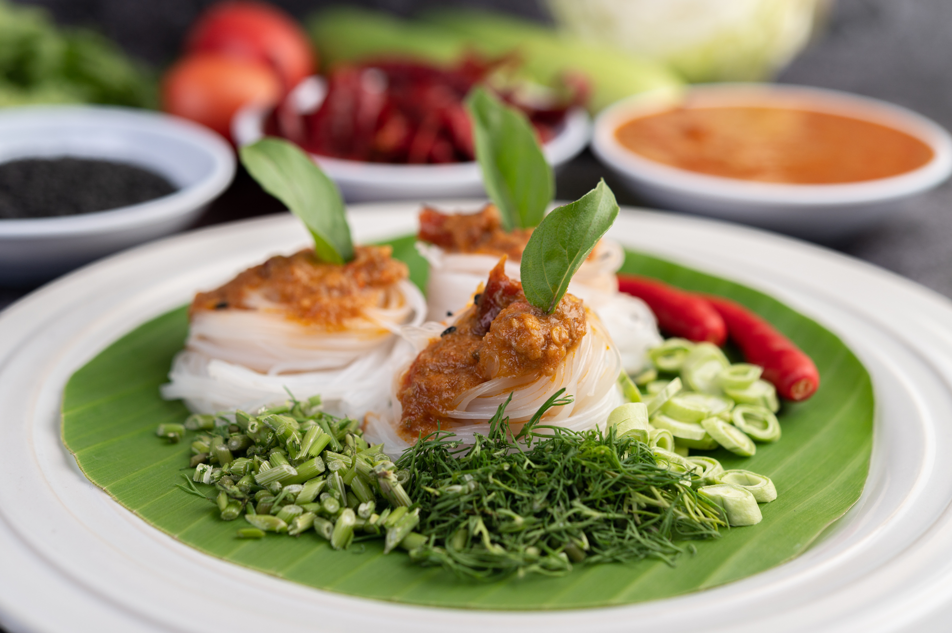 Overhead flat-lay of all ingredients for Sumptuous Cambodian Prahok Ktis with Coconut Milk and Fermented Fish laid out on a kitchen surface.