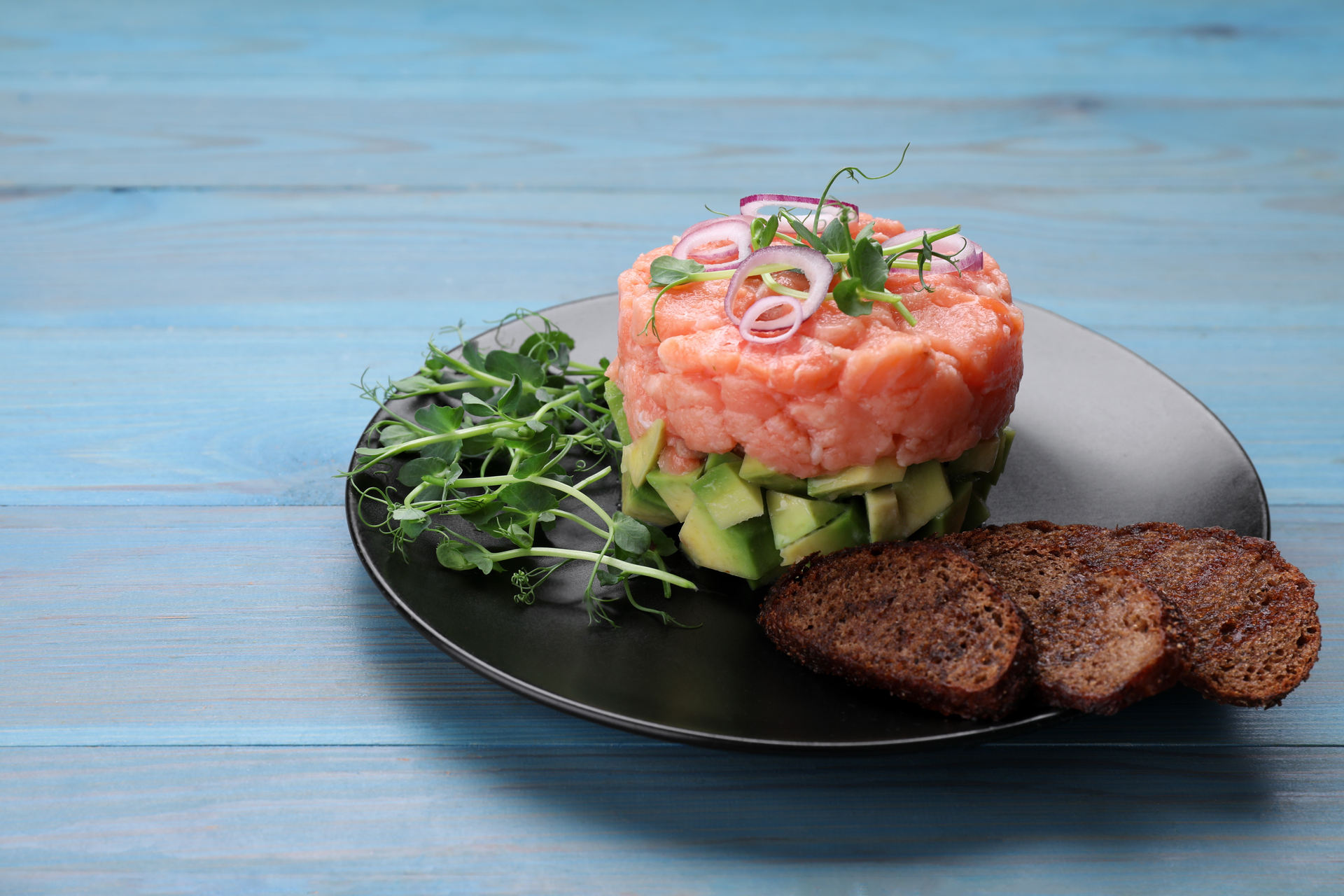 Overhead flat-lay of all ingredients for Swedish Gravlax Tartare with Dill and Capers laid out on a kitchen surface.
