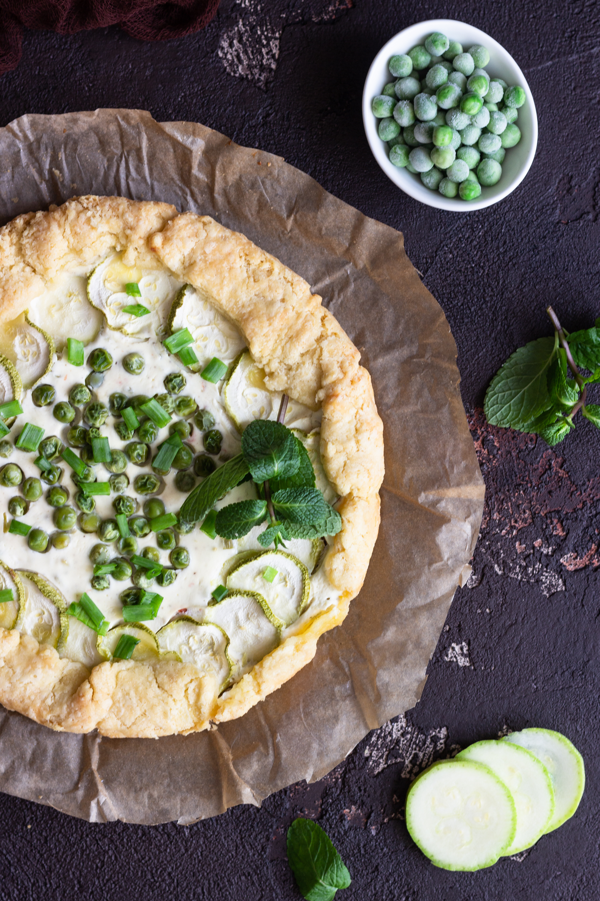 Overhead flat-lay of all ingredients for Swedish Västerbottensost Pie with Dill Cream laid out on a kitchen surface.