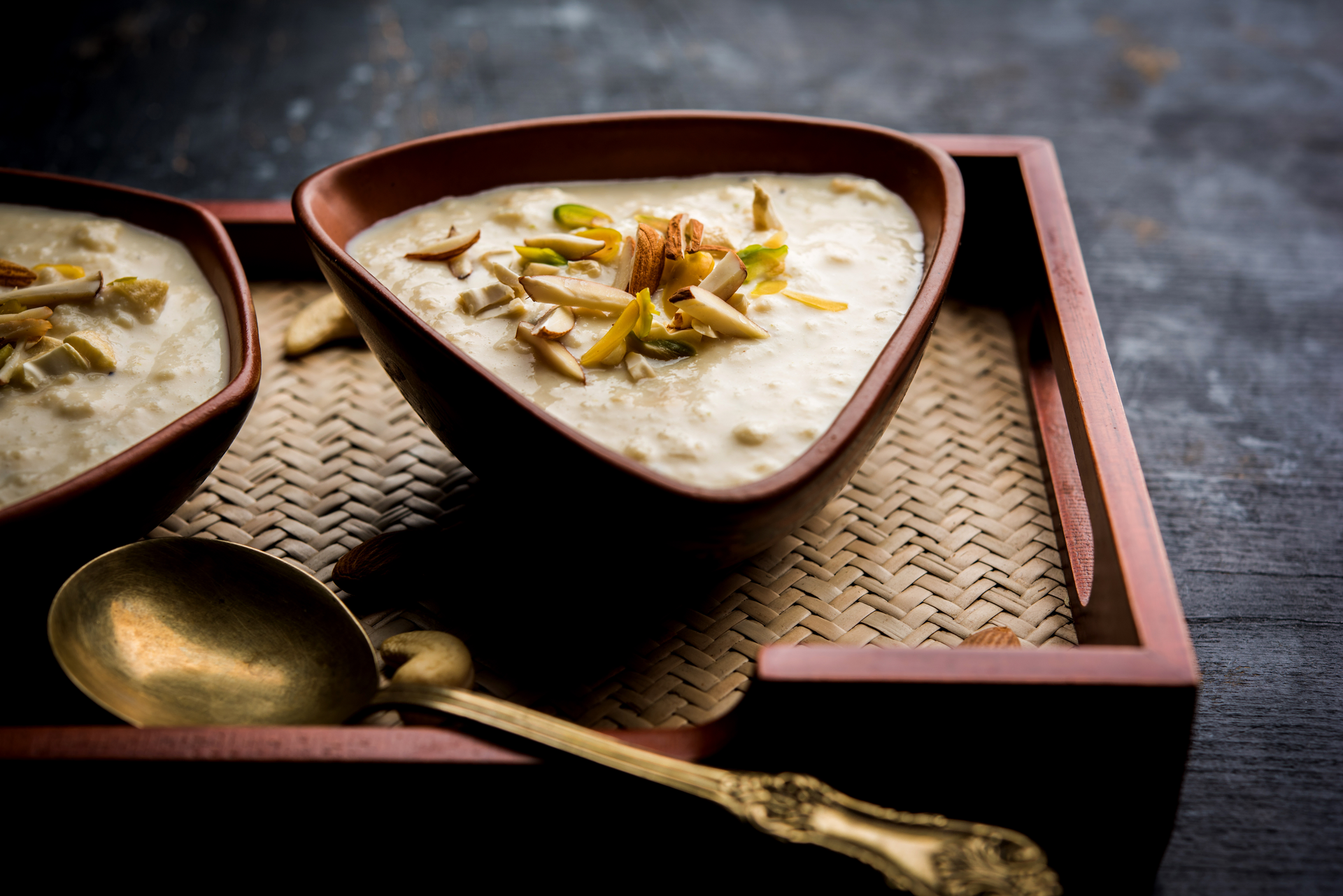 Overhead flat-lay of all ingredients for Sweet Bangladeshi Payesh with Cardamom and Cashews laid out on a kitchen surface.