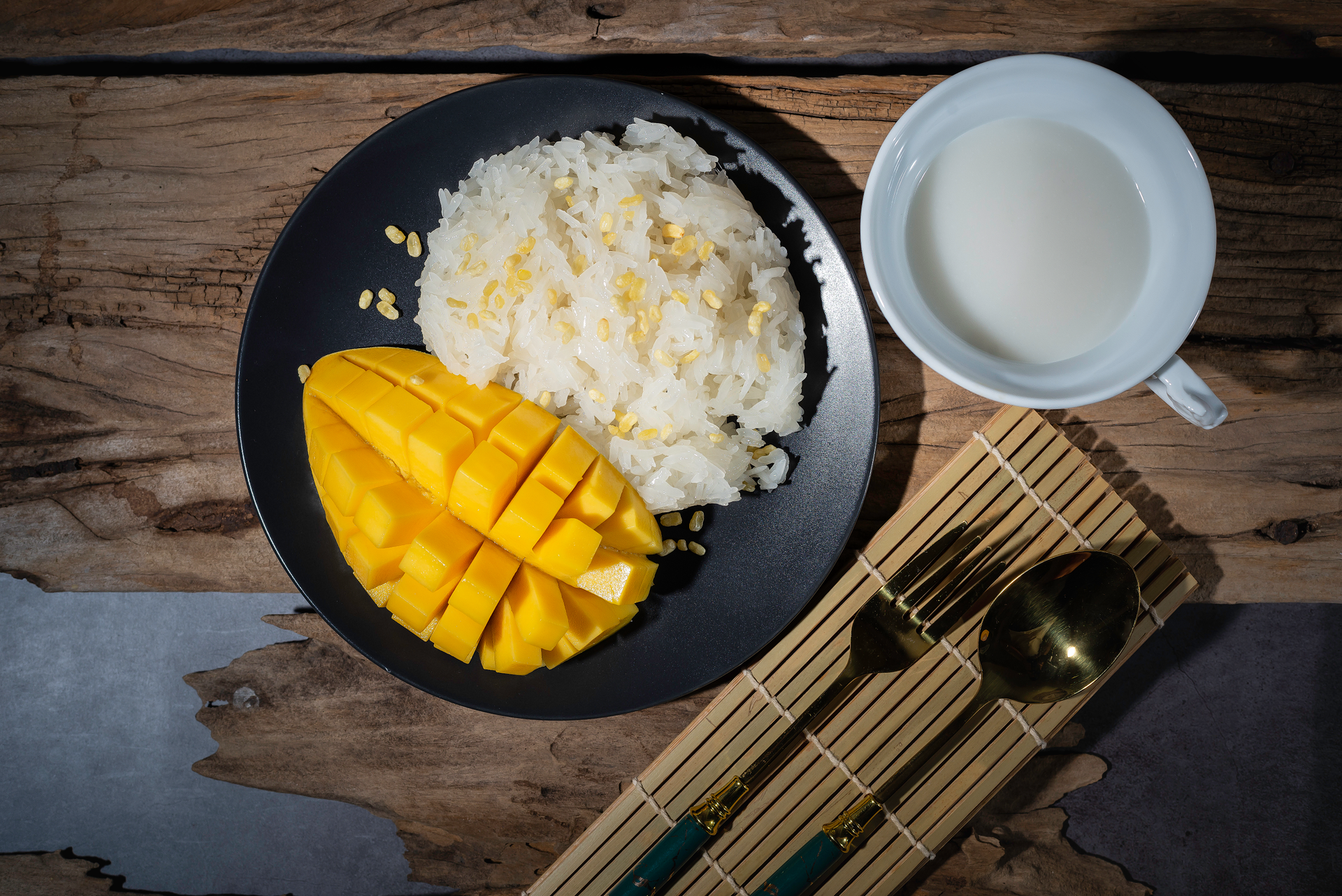 Overhead flat-lay of all ingredients for Sweet Thai Black Sticky Rice with Mango laid out on a kitchen surface.