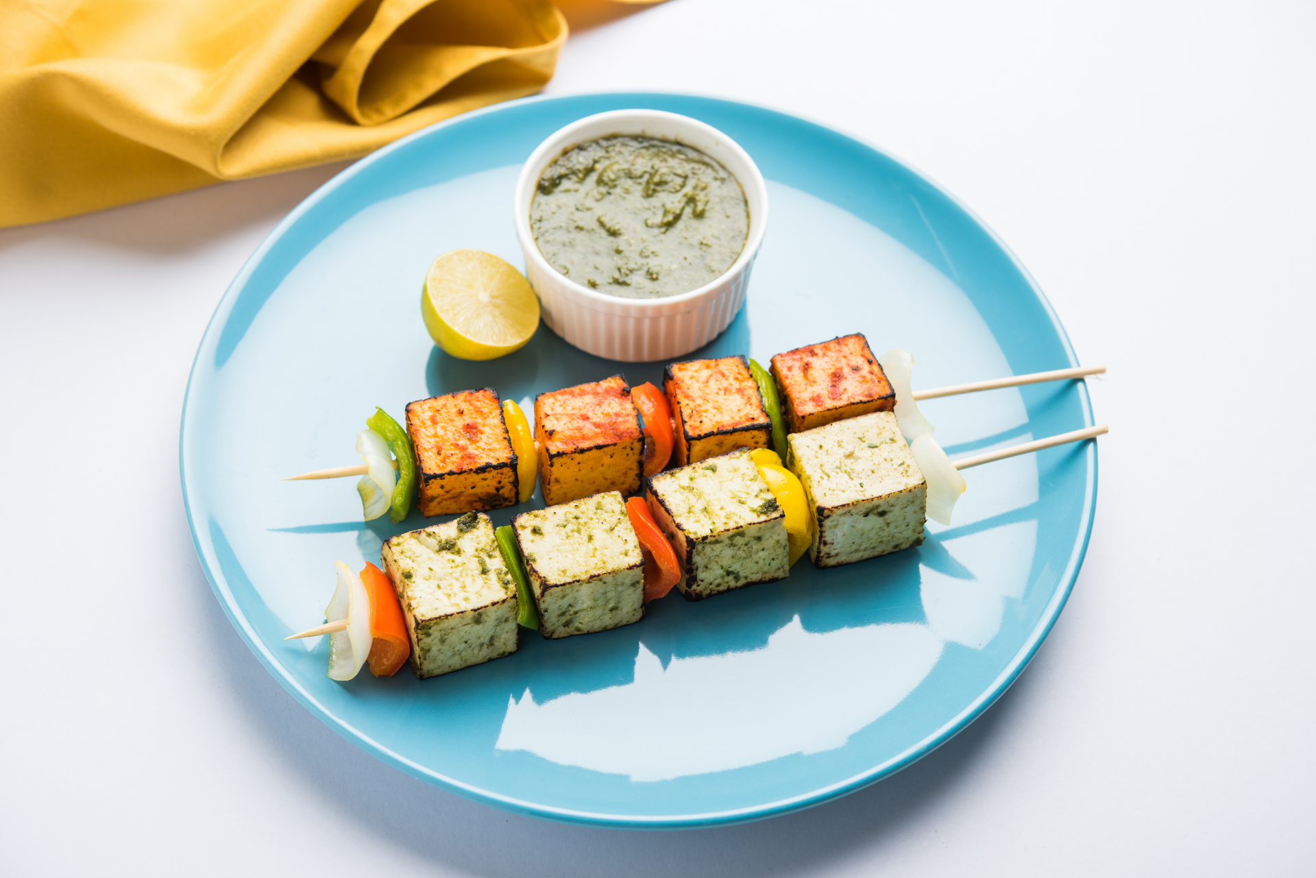 Overhead flat-lay of all ingredients for Tandoori Paneer Skewers with Mint Chutney laid out on a kitchen surface.