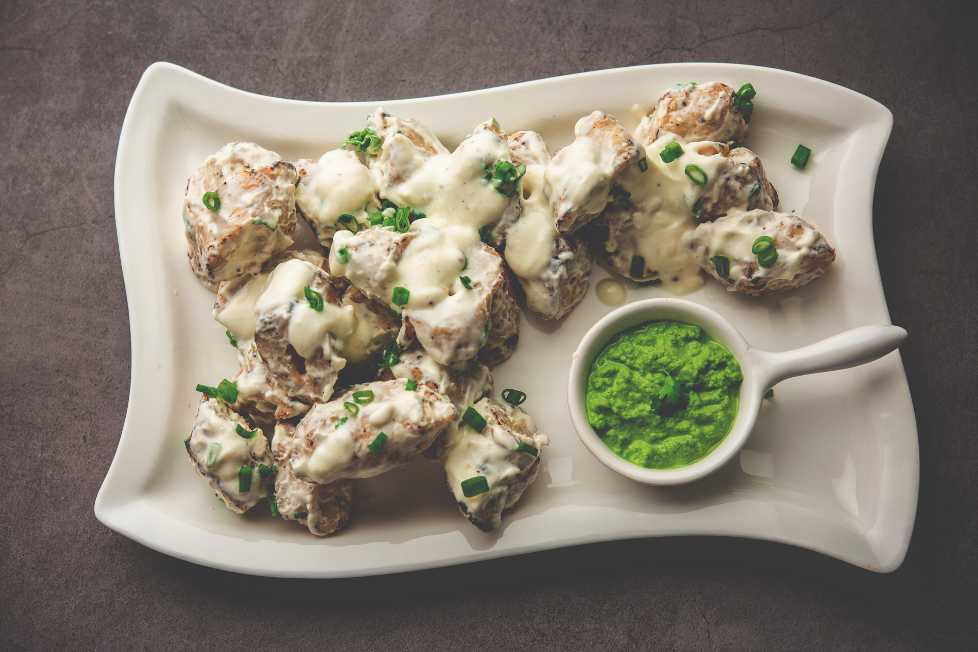 Overhead flat-lay of all ingredients for Tandoori Spiced Cauliflower Steaks with Coriander Yogurt Sauce laid out on a kitchen surface.