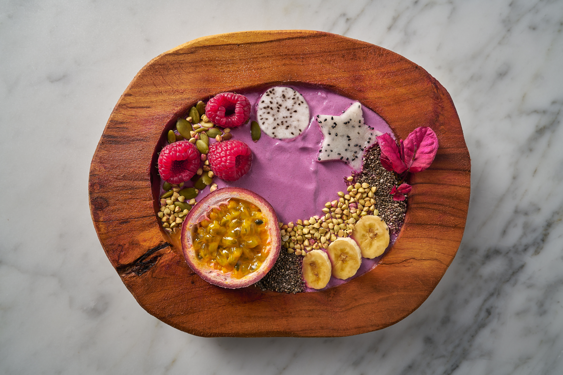 Overhead flat-lay of all ingredients for Tangy Brazilian Acai Bowl Infused with Passion Fruit Syrup laid out on a kitchen surface.